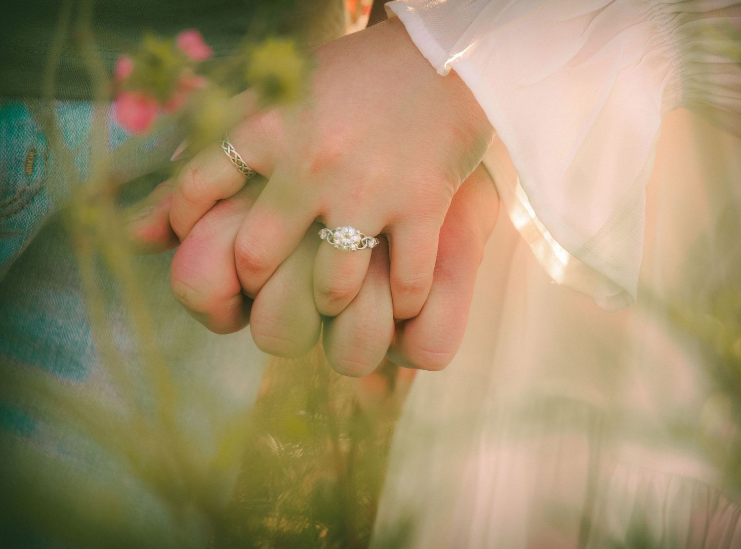 Artistic close-up of engagement ring with dreamy bokeh effect.
