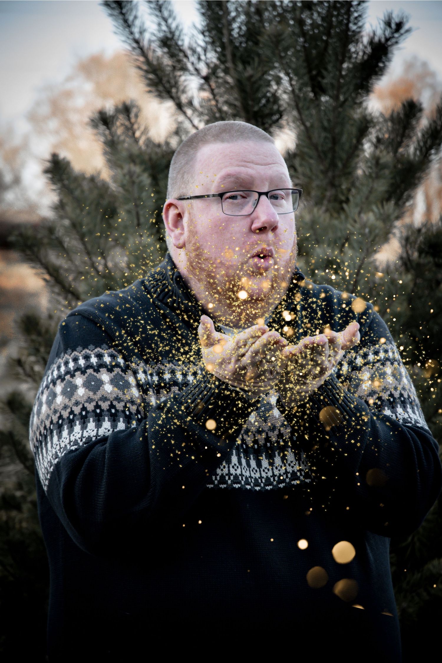 Person in winter sweater blowing glitter in a dramatic sequence against evergreen trees.