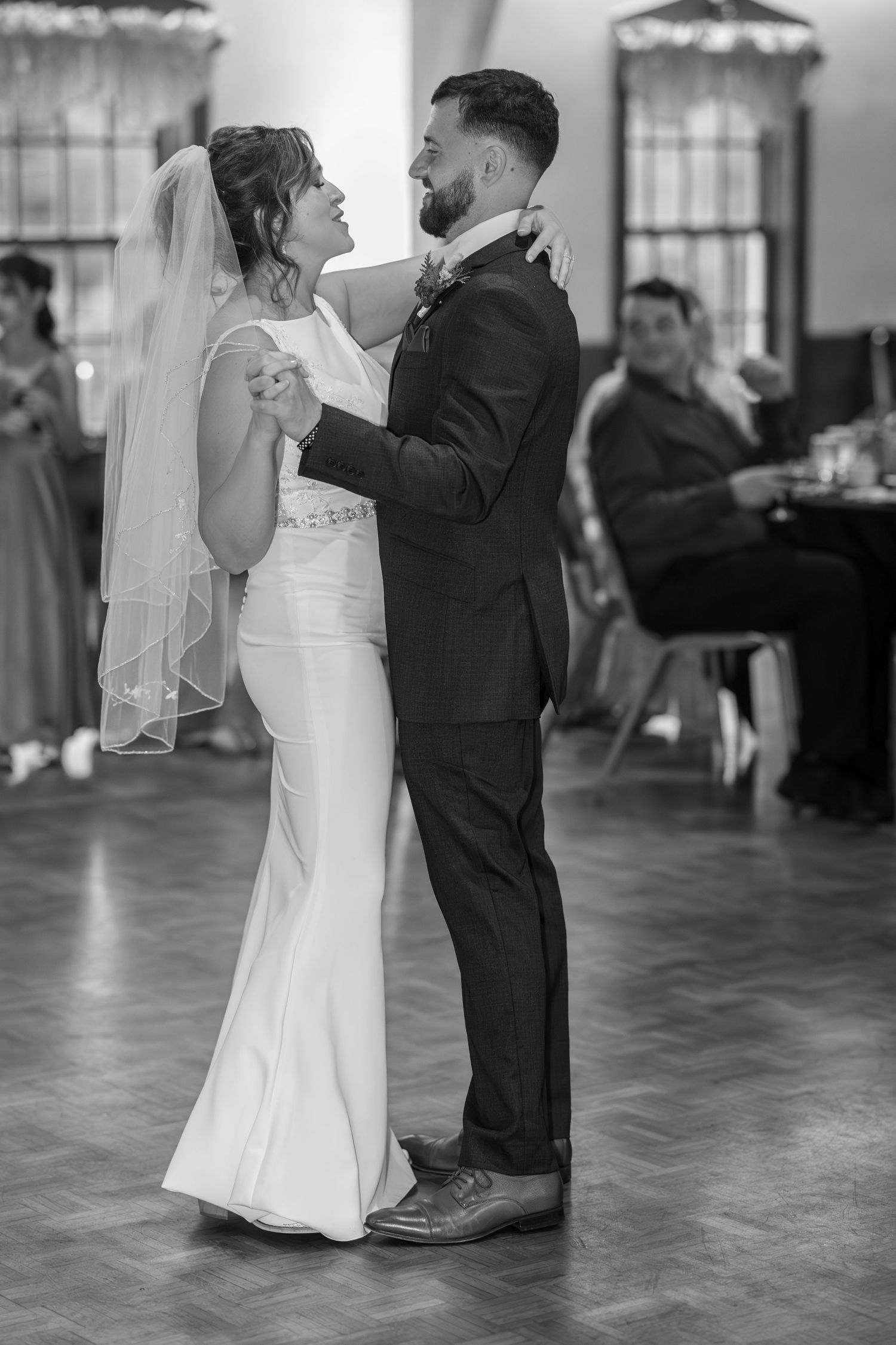 A sequence of black and white photos showing a couple dancing at their wedding reception on a hardwood floor.