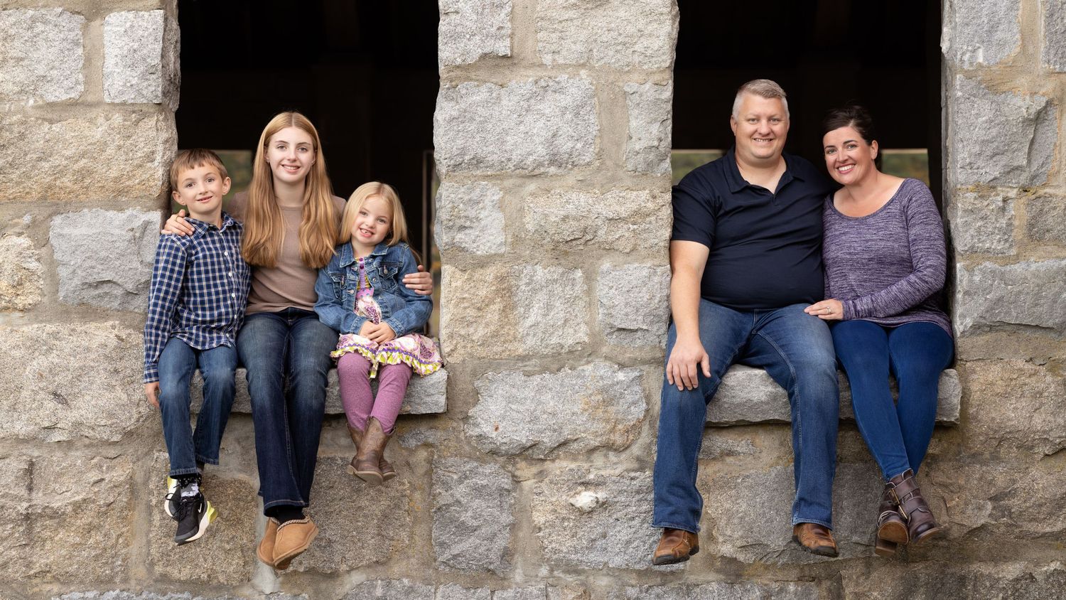 A series of people sitting in stone window alcoves at different angles, creating a repeating architectural pattern.