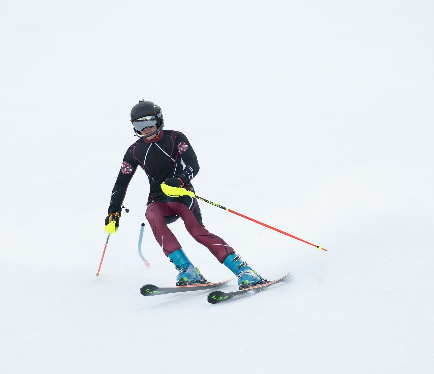 Skier in dark winter gear performs dynamic carving turns on snowy slopes in sequence of action shots.