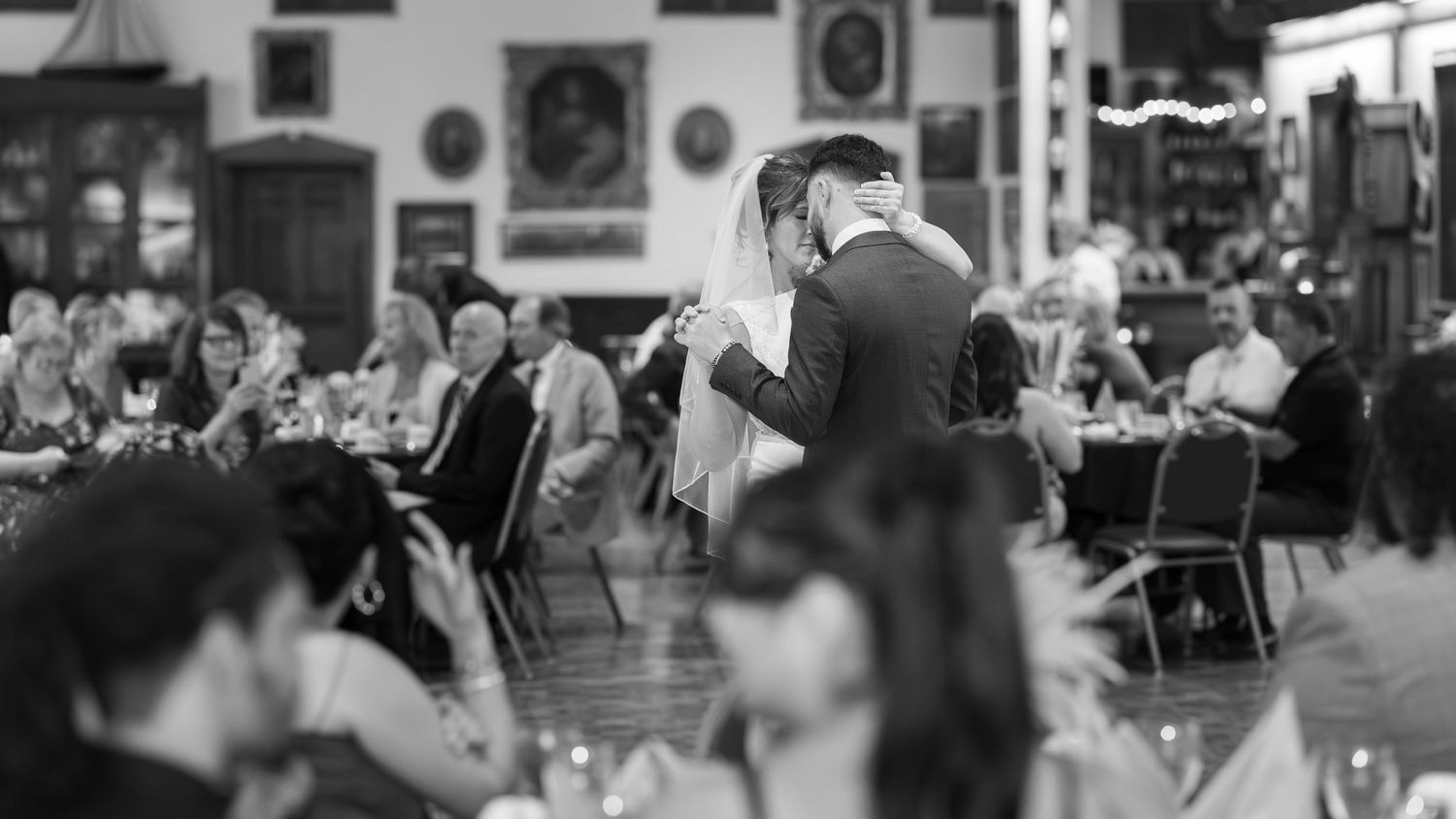 A black and white panoramic collage of people dining in a busy restaurant interior.