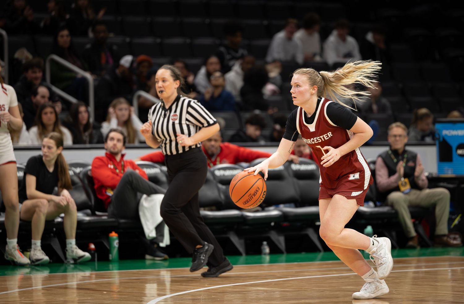 Basketball players compete for possession during an intense game on a hardwood court.