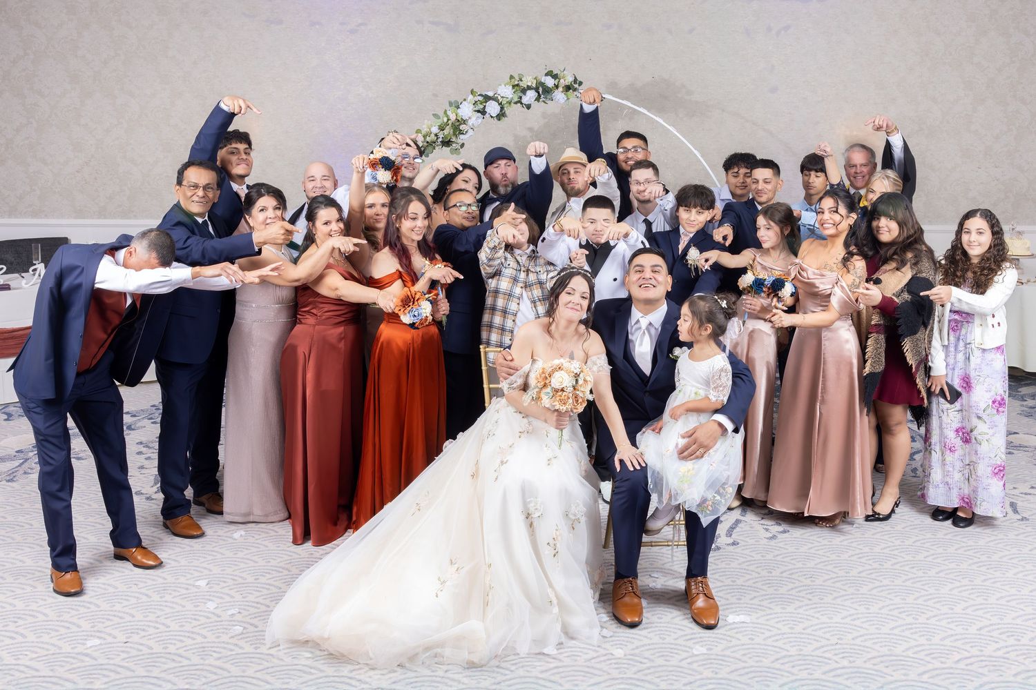 Wedding party members pose together on the floor in a fun and playful sequence of group photos.