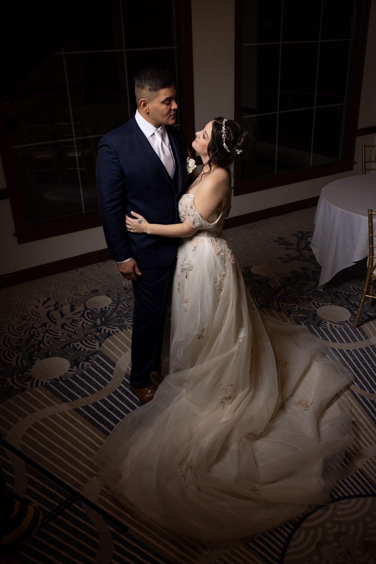 A romantic wedding dance sequence showing a couple in formal attire twirling on a patterned carpet in dim lighting.