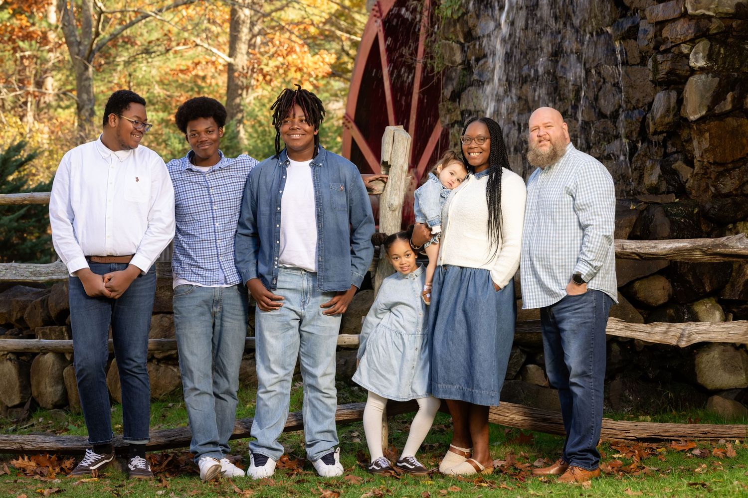 A group of people in coordinated blue and white casual outfits sitting together on stone steps outdoors.