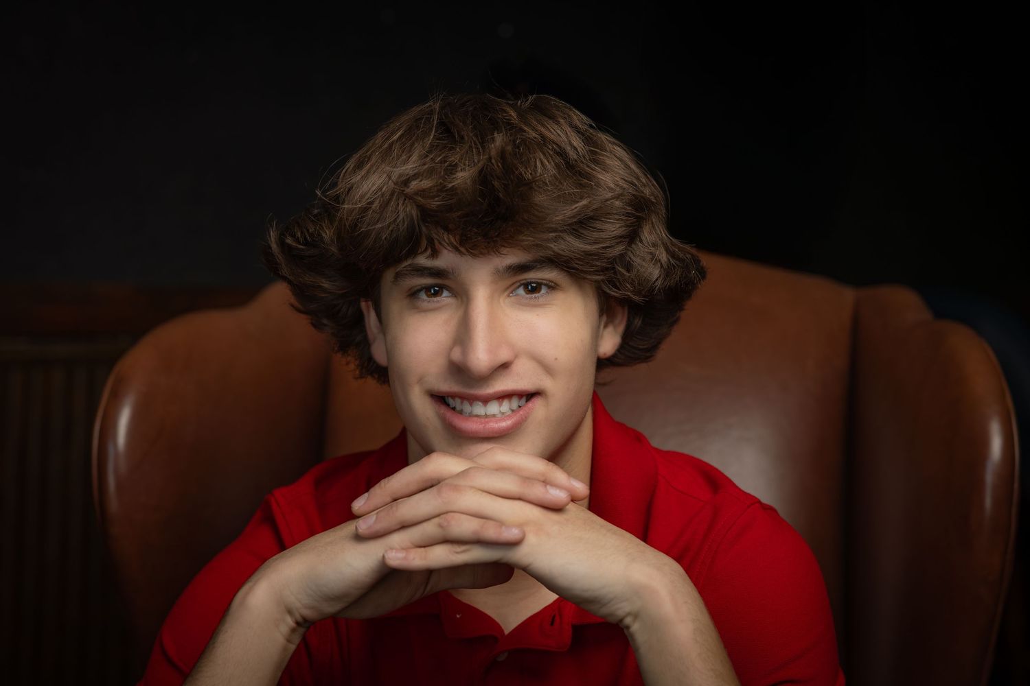 A series of similar portrait photos showing someone in a red shirt against a dark background.