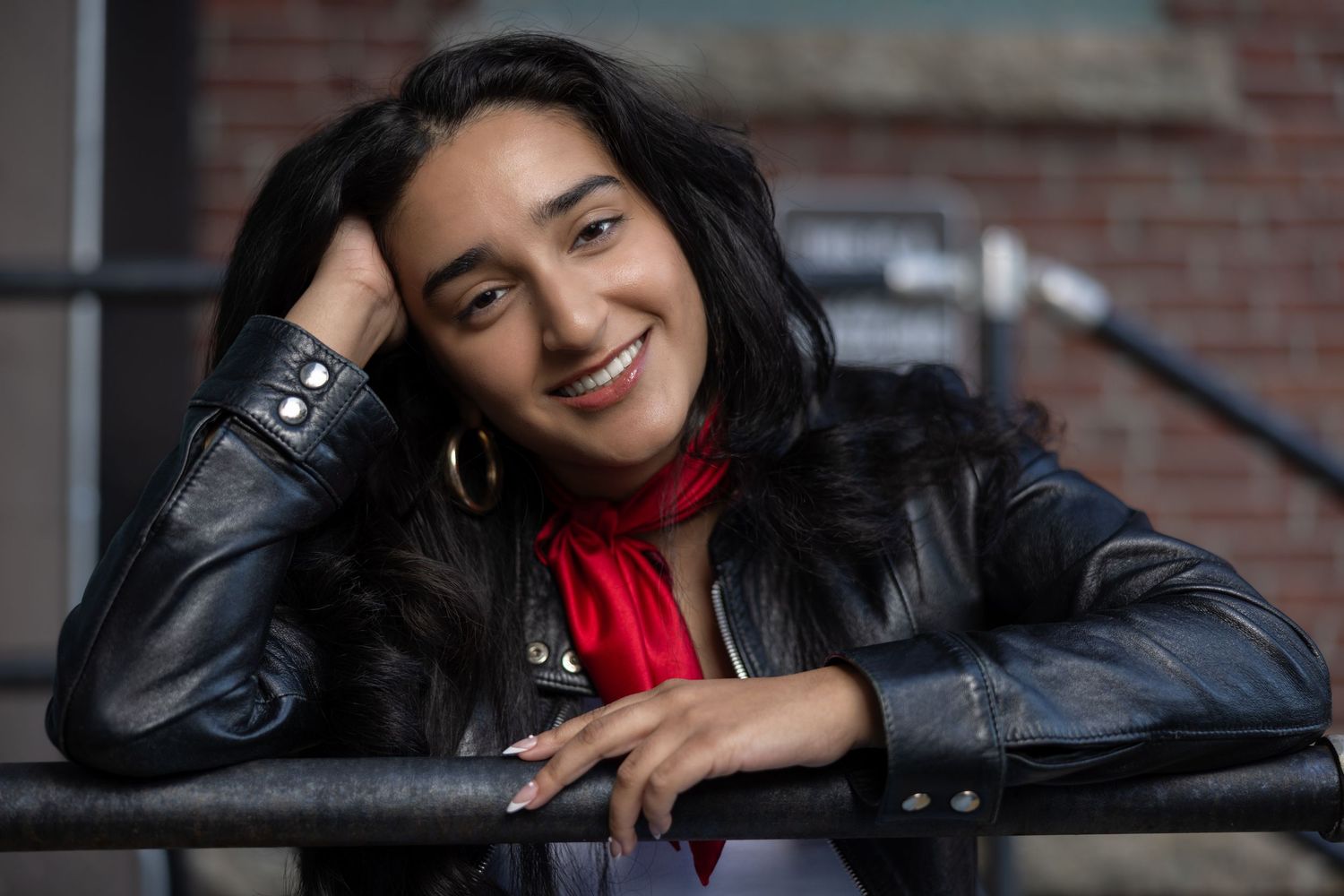 A series of casual portrait shots showing a person in a black jacket against a brick wall background.