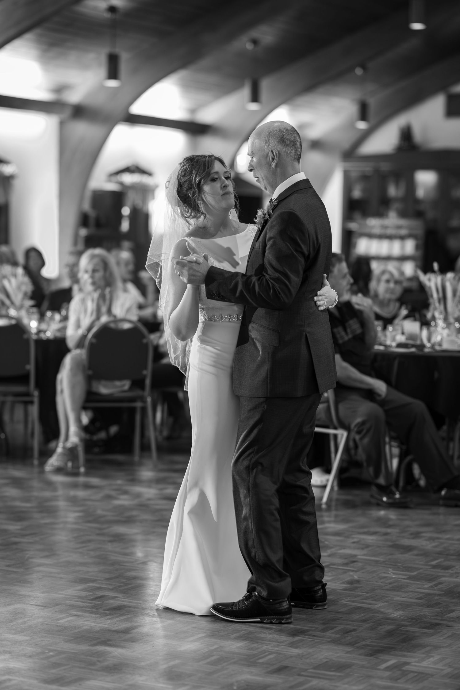 A couple shares an intimate dance at a wedding reception, shown in a black and white photo sequence.