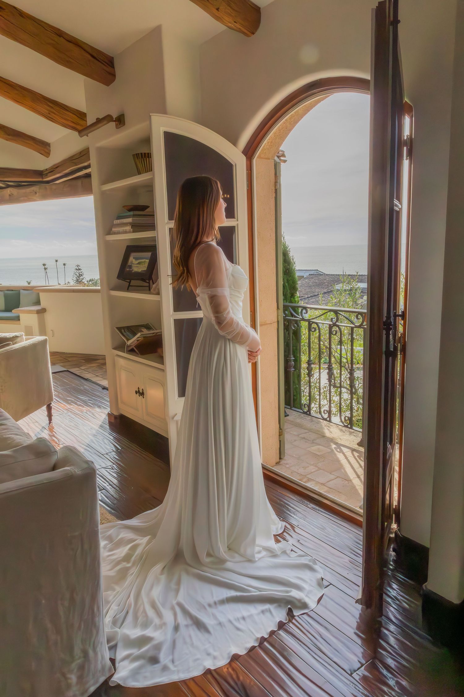 Bride gazing out window during quiet getting-ready moment before ceremony