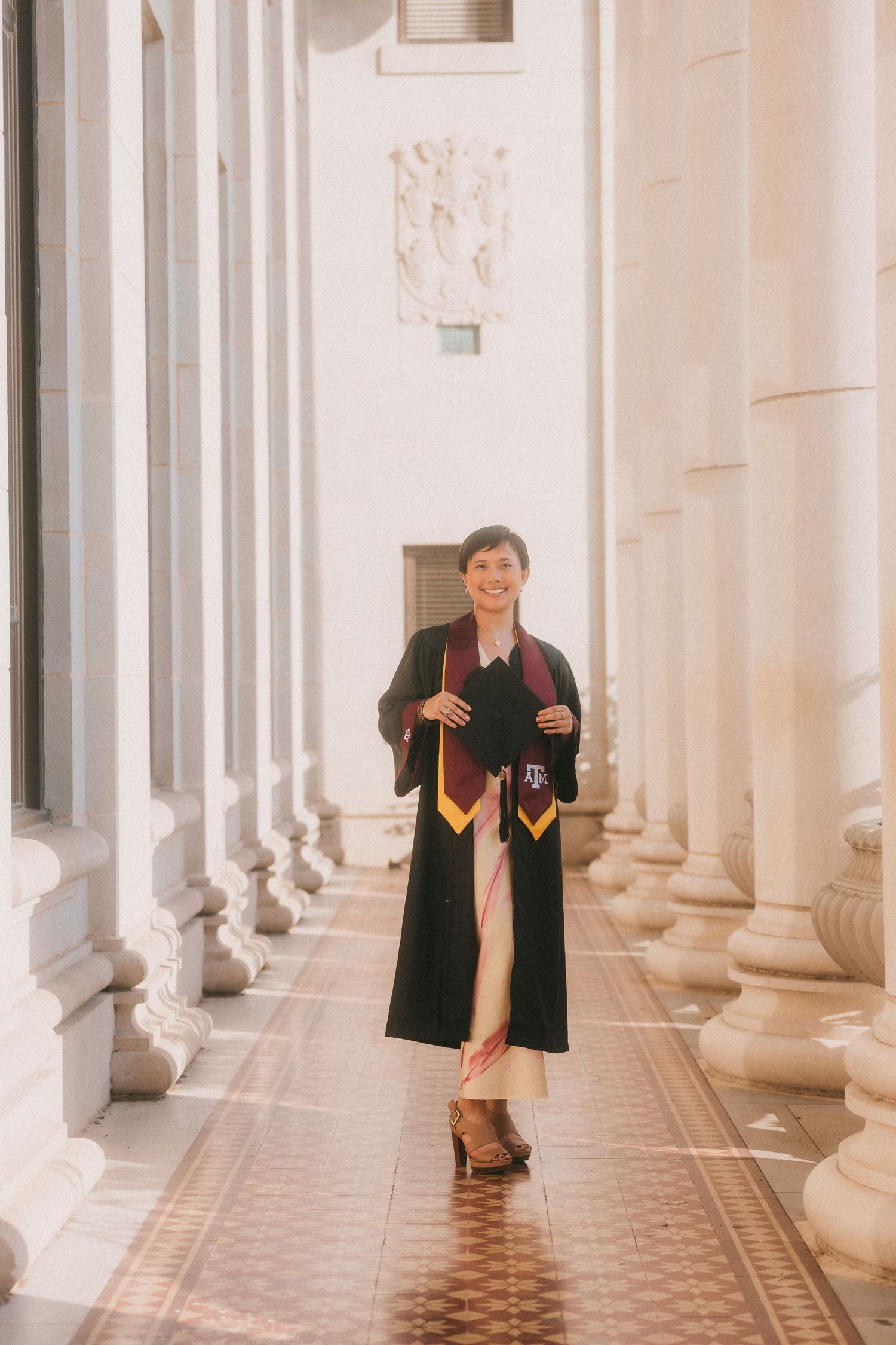 College graduate celebrating graduation in cap and gown photographed by Magnolia Events & Photography