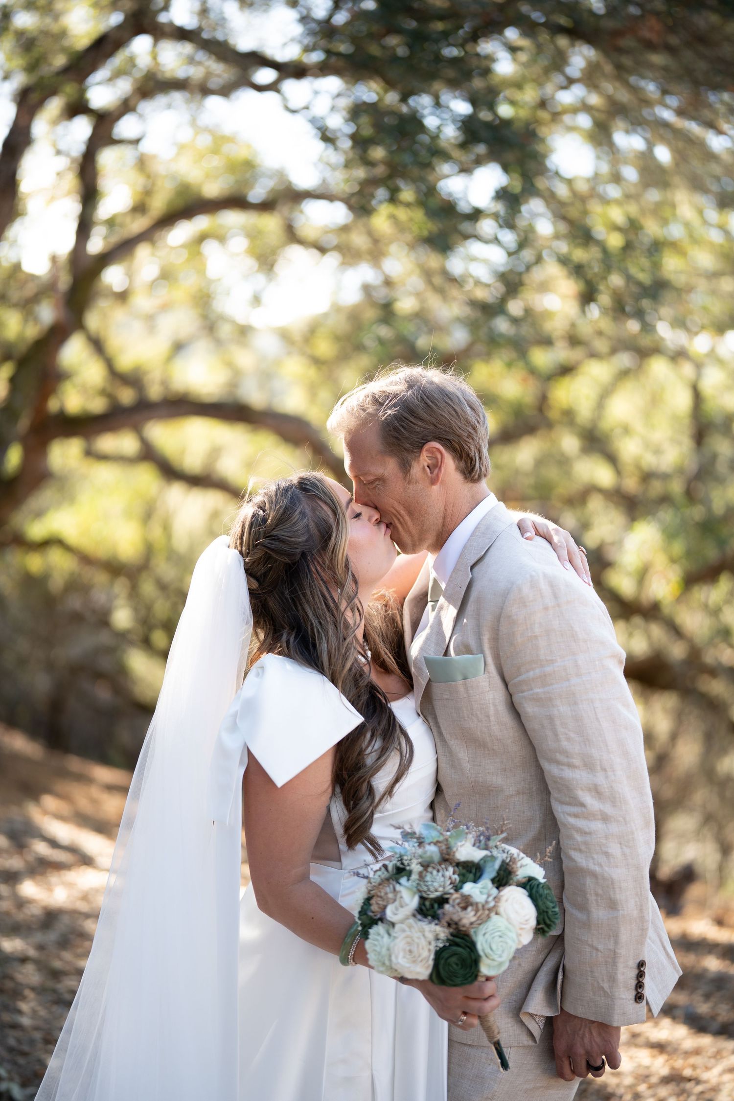 Carmel Valley Wedding A romantic wedding moment captured outdoors with a beautiful bouquet of blue and white flowers in a natural setting.