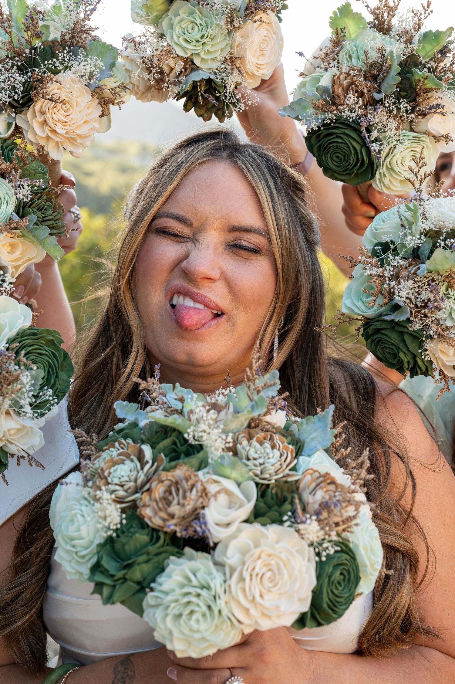 A playful moment surrounded by a beautiful floral arrangement featuring mint green and cream colored roses with greenery.