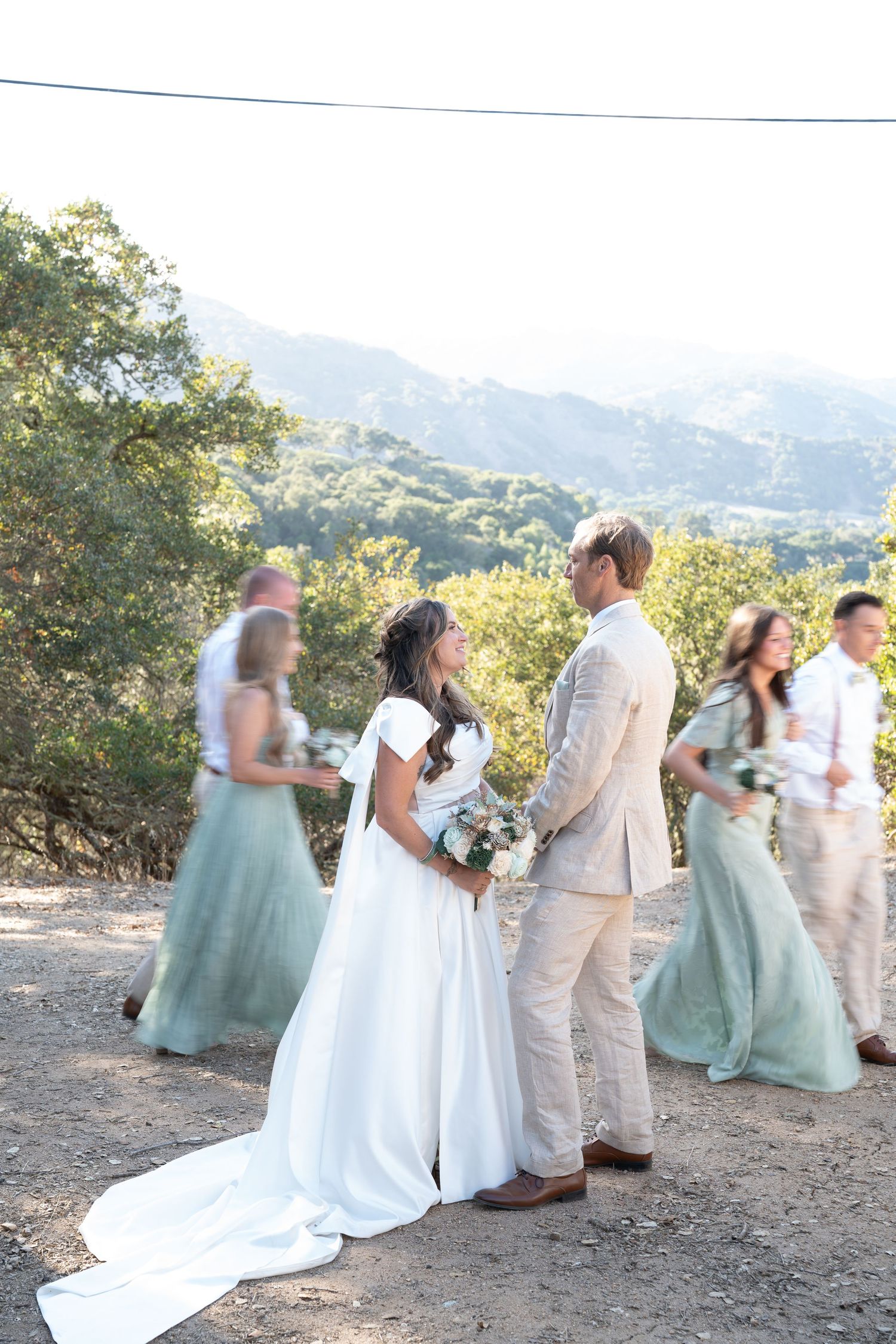 Carmel Valley Wedding, California Wedding party poses outdoors on a hilltop with scenic mountain views in the background.