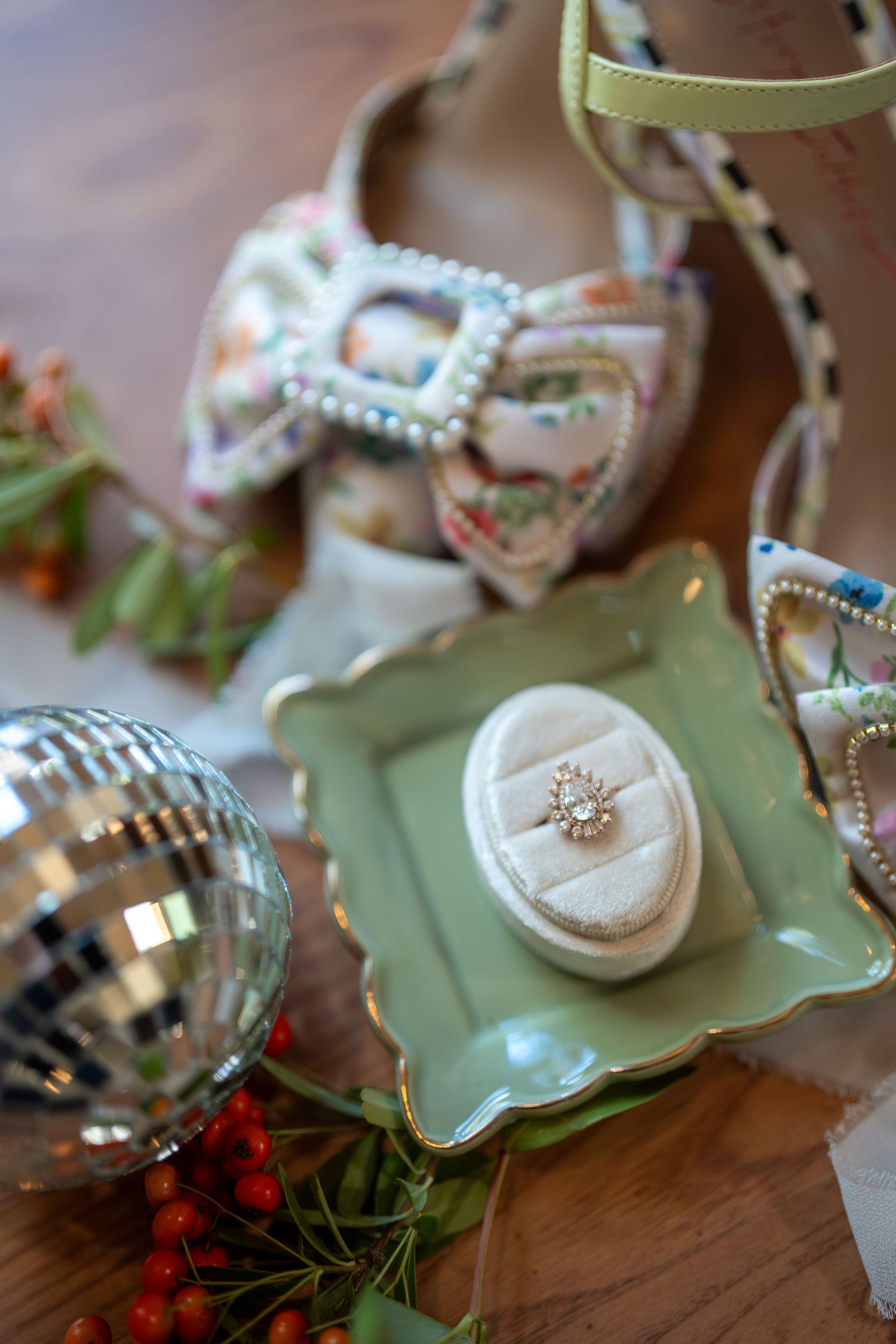 Vintage-style jewelry and decorative items displayed on mint green ceramic plates against a wooden surface.