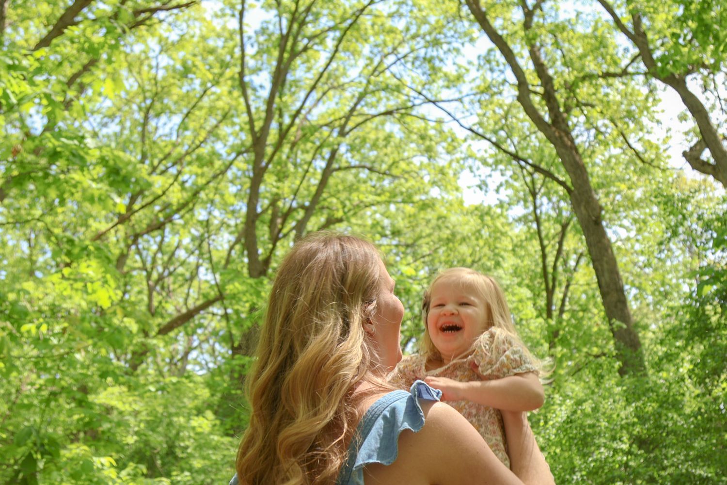 Mother holding toddler daughter in sunlight forest photo in Cedar Lake Indiana