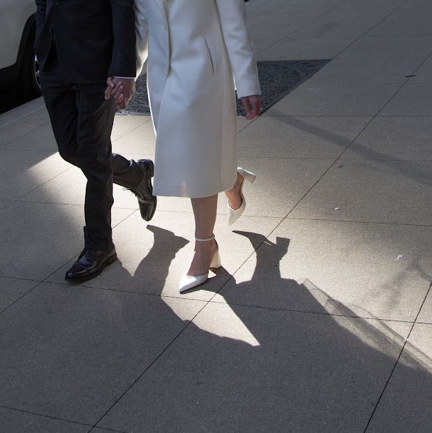 Bride and Groom walk on Chicago streets as sun casts shadows, artsy cropped photo of only their lower halves