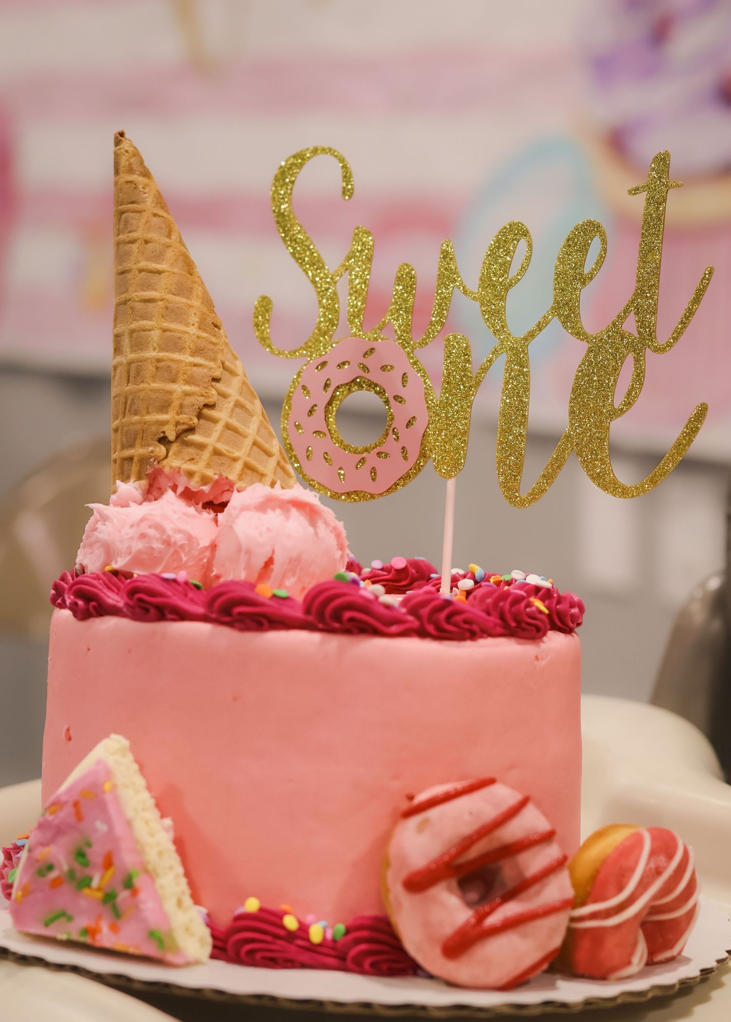 First Birthday pink cake with cake topper that says 