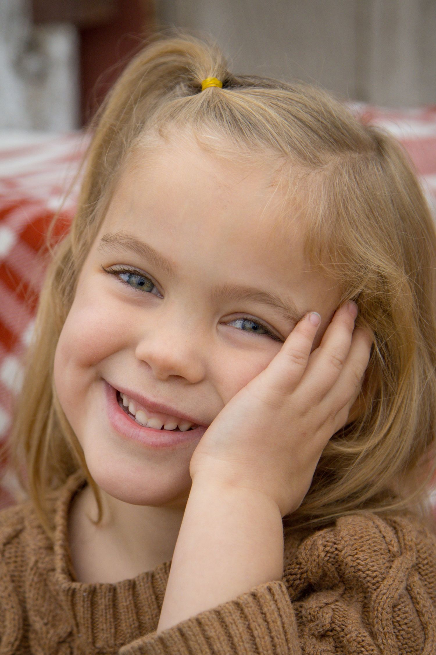 Close up photo of little girl smiling big, eyes are sparkling
