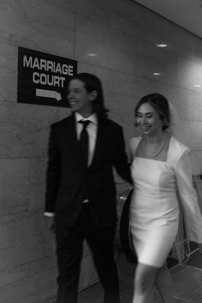 Bride and groom walk past marriage court sign at the chicago courthouse