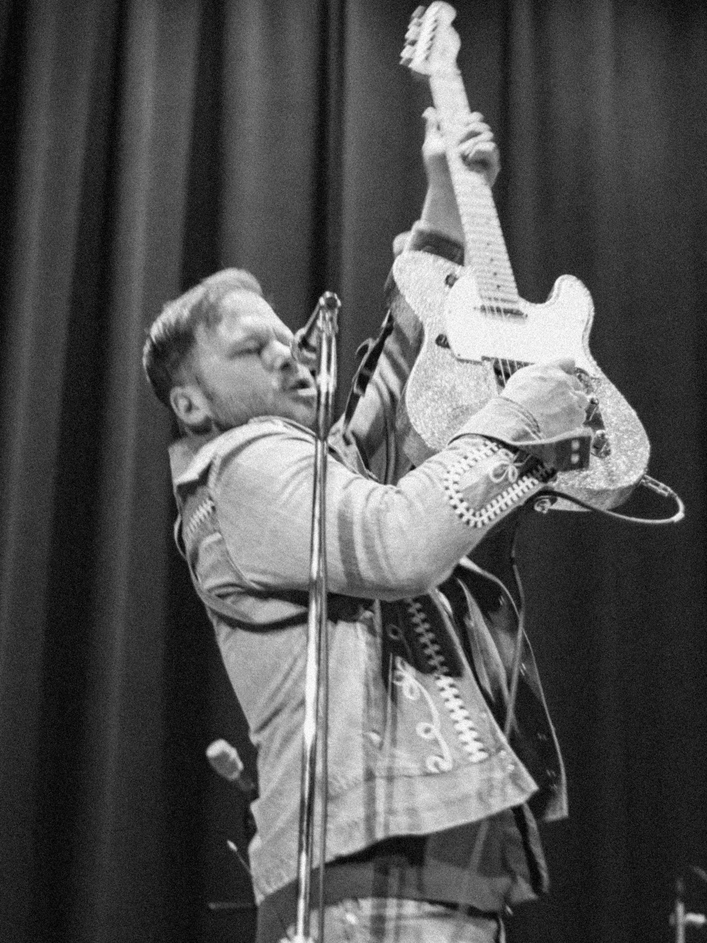 Live music event photography in Chicago by Kristin Photo Co. Lead Guitar player holds up and plays guitar
