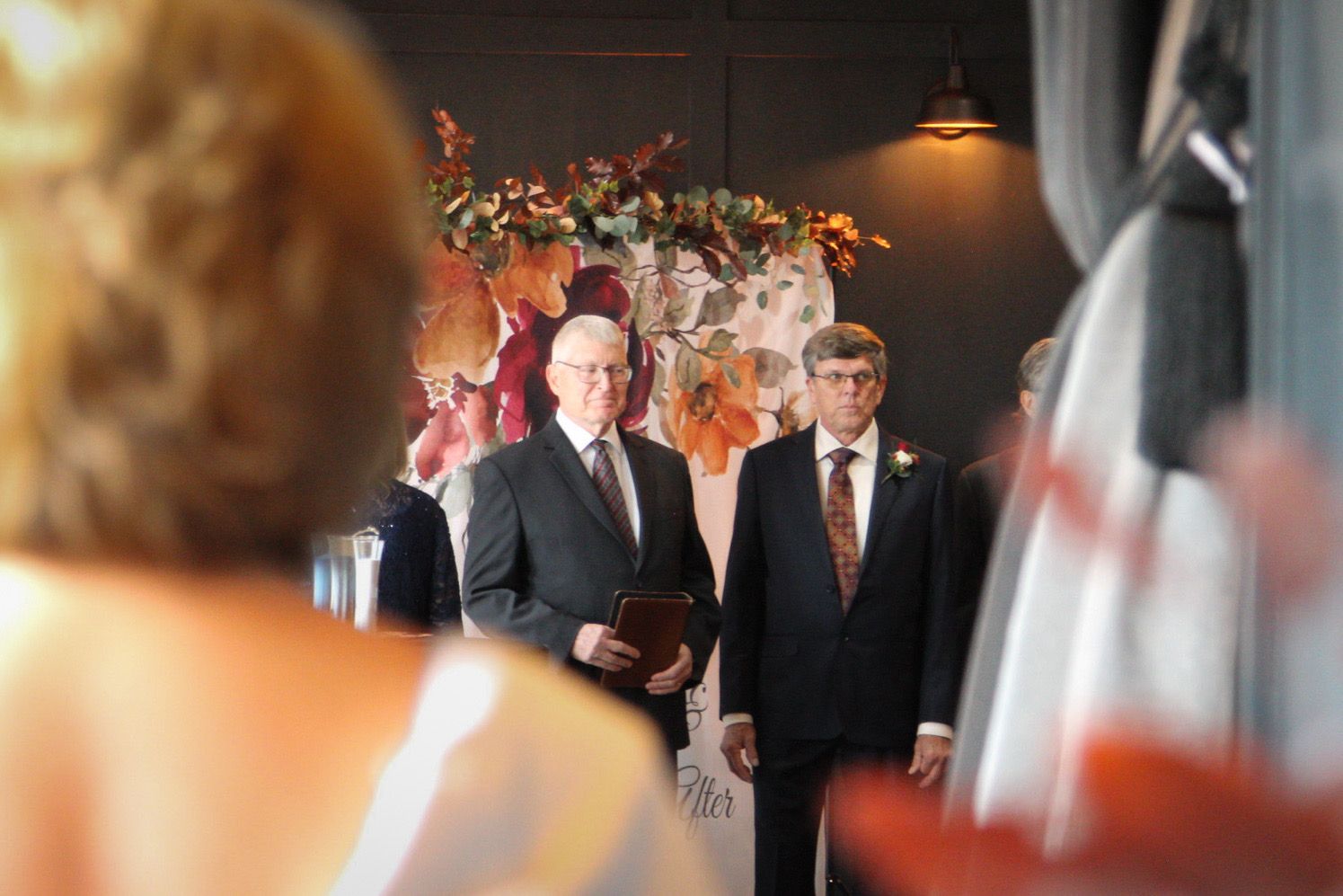 Close up of bride, and Groom and pastor are over her shoulder watching her begin to walk down the aisle