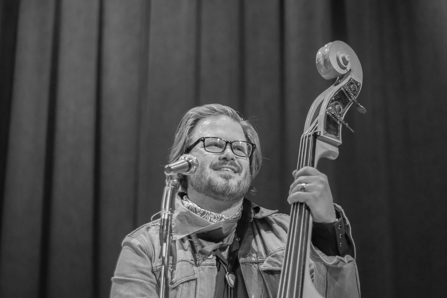 Bass player of the band Iron Horse smiles out at the crowd while he plays his bass