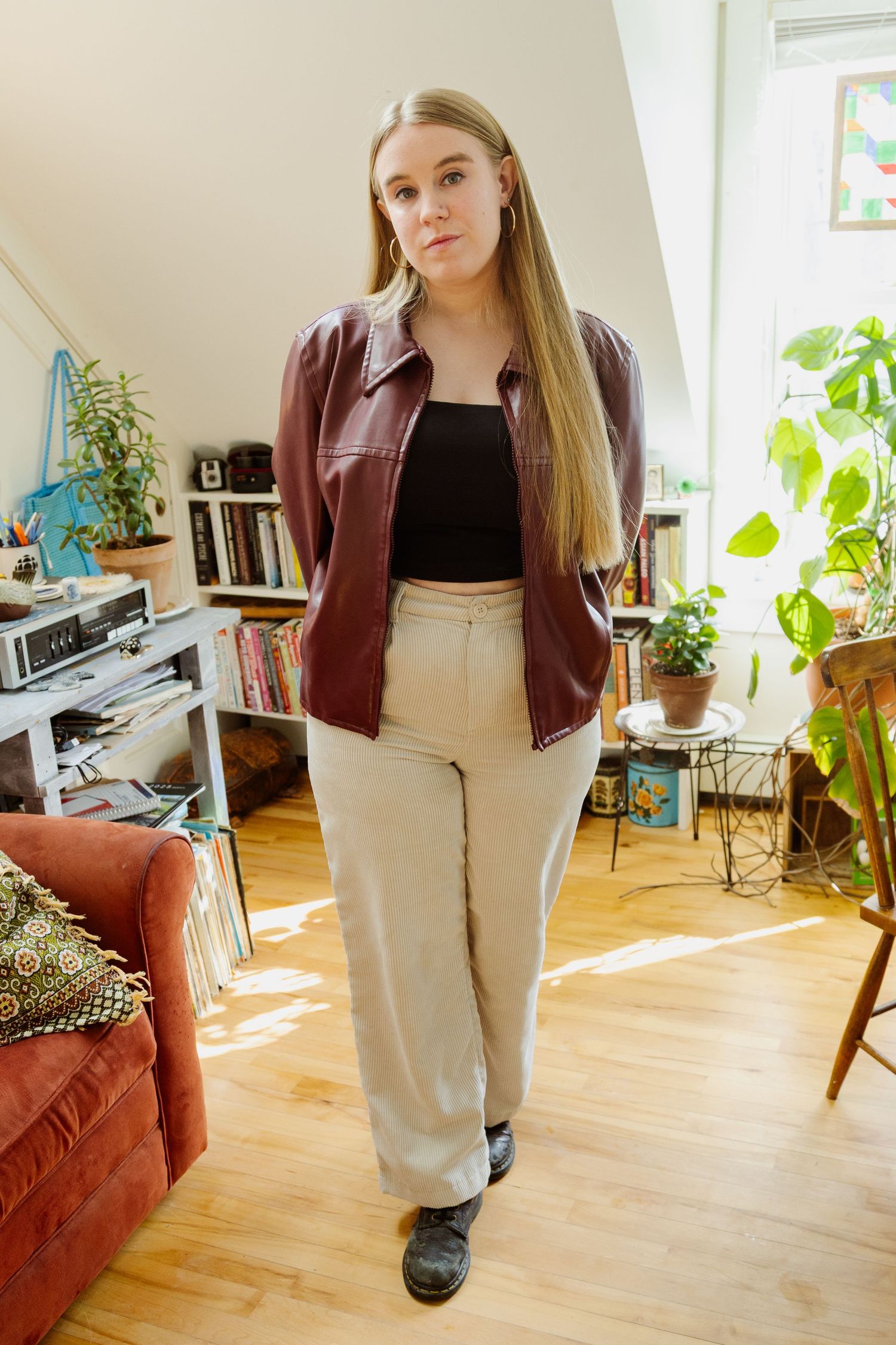 A series of fashion photos showing someone in a brown leather jacket and beige pants posing in a sunlit living room.