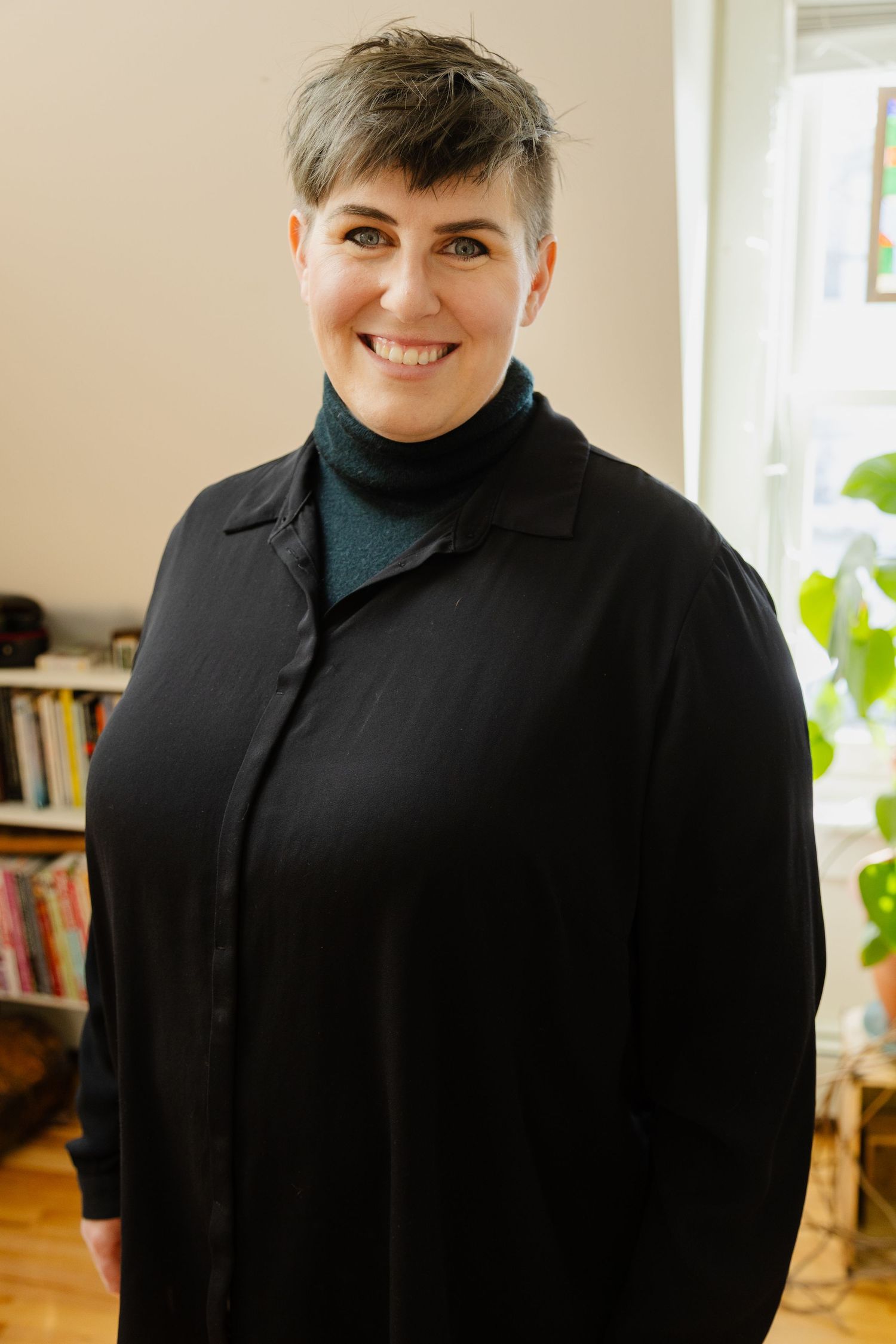 A series of four similar photos showing someone in a black shirt smiling against a light-colored interior background.