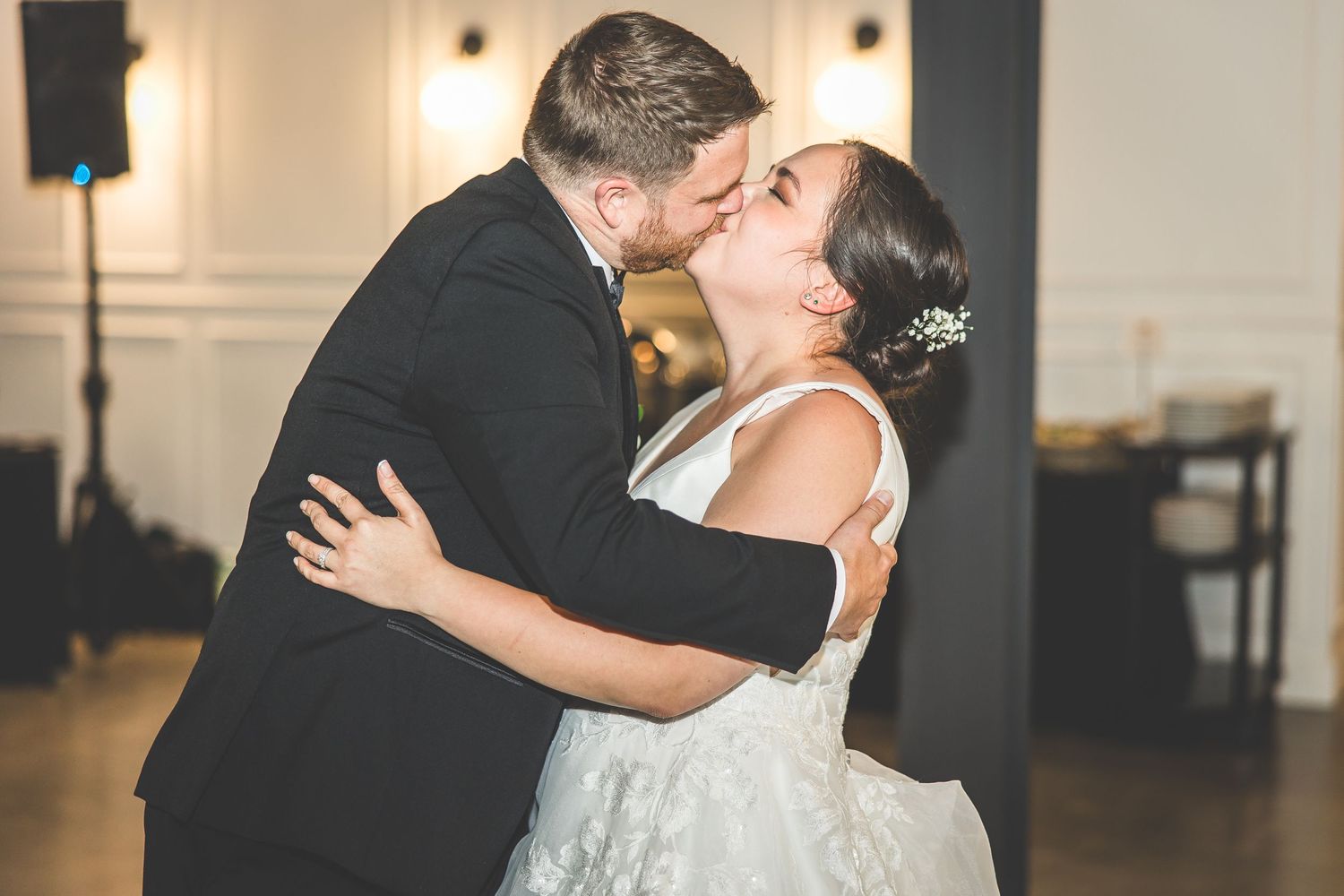 A romantic moment captured during a wedding first dance in a reception hall.
