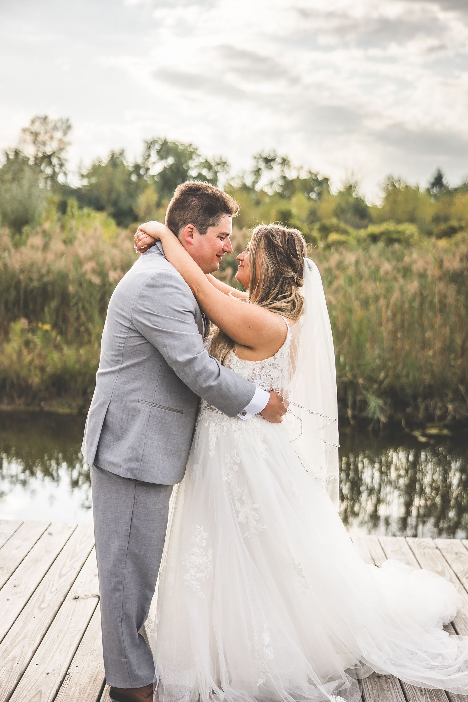 Intimate wedding moments captured on lakeside dock during golden hour.