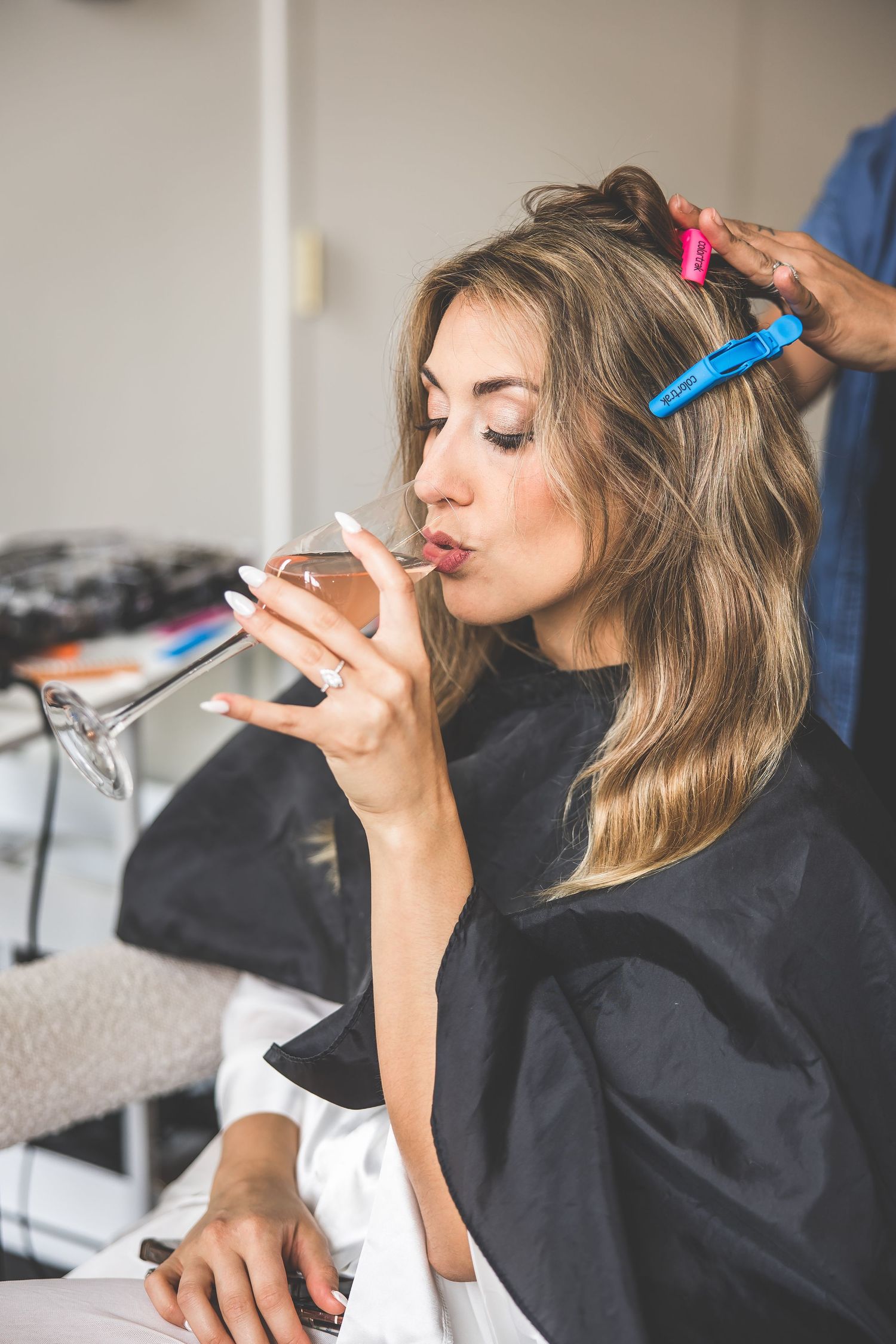 Hair and makeup styling session during wedding day preparations.