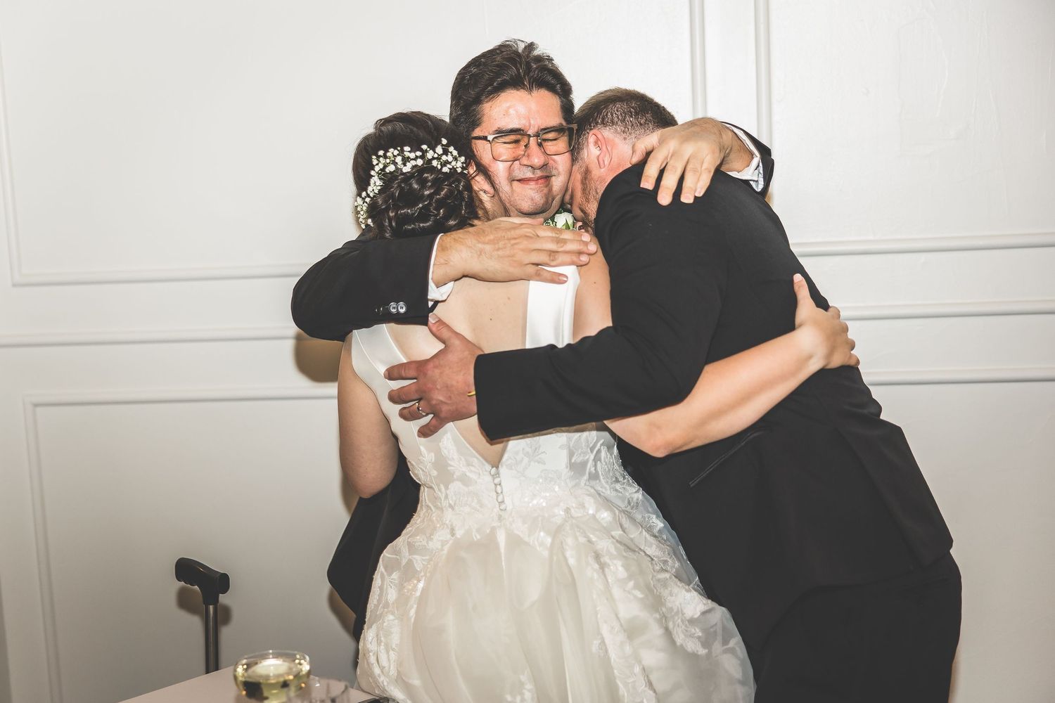 Emotional embraces shared between wedding guests at an elegant indoor venue.