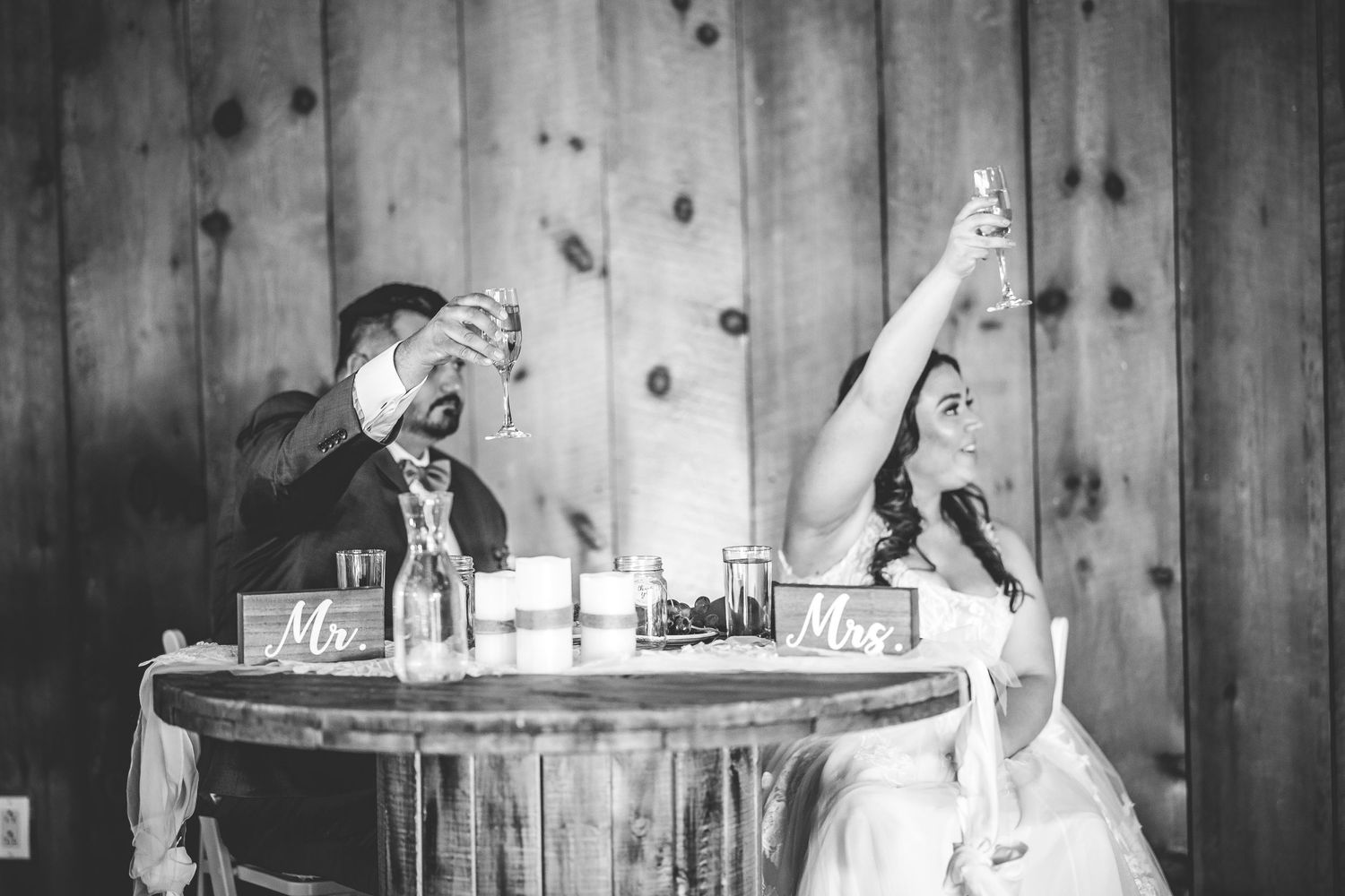 Black and white photos of a romantic wedding reception in a rustic barn setting.