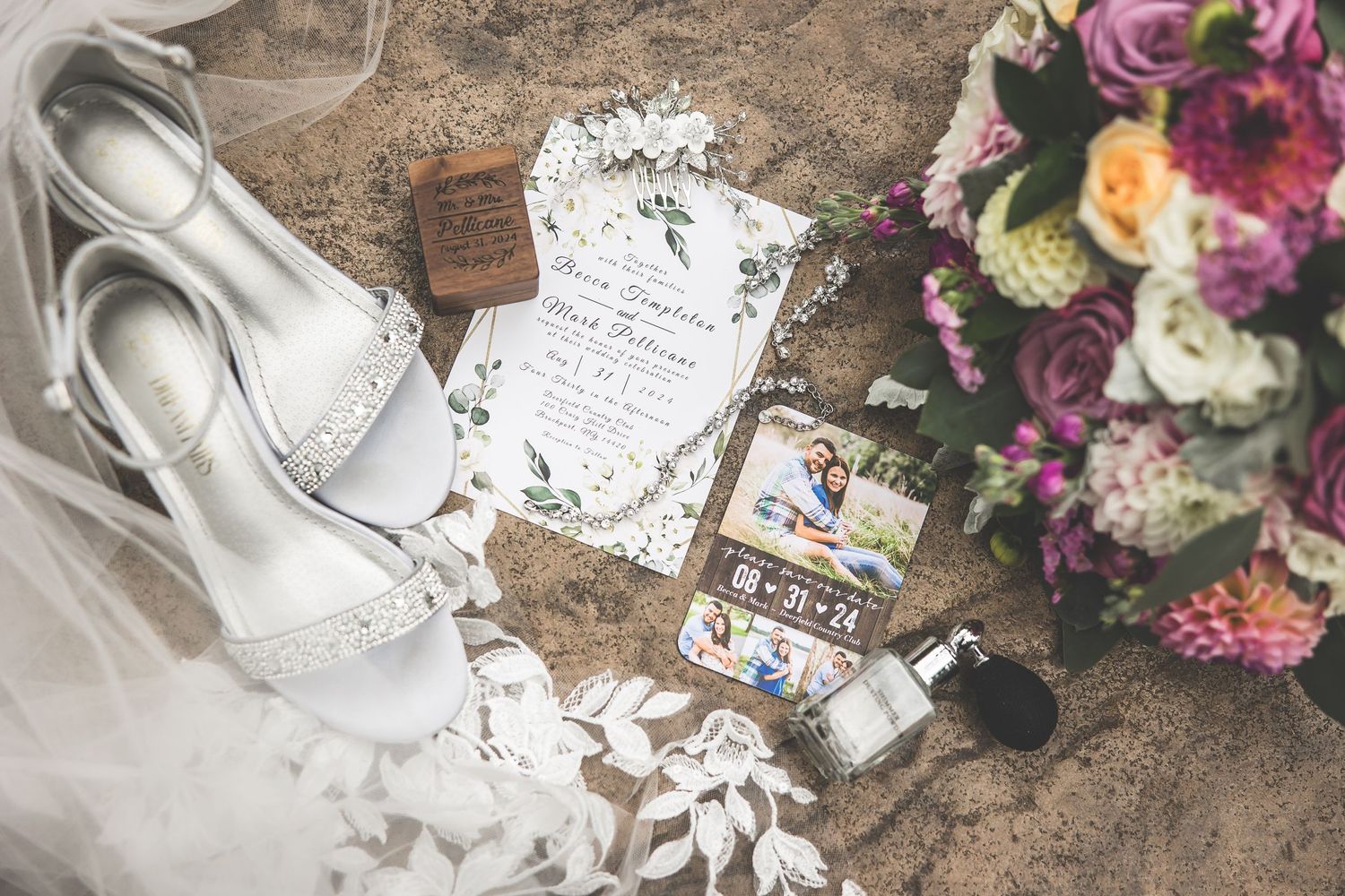 Wedding details flatlay with white shoes, invitation, and colorful floral bouquet.
