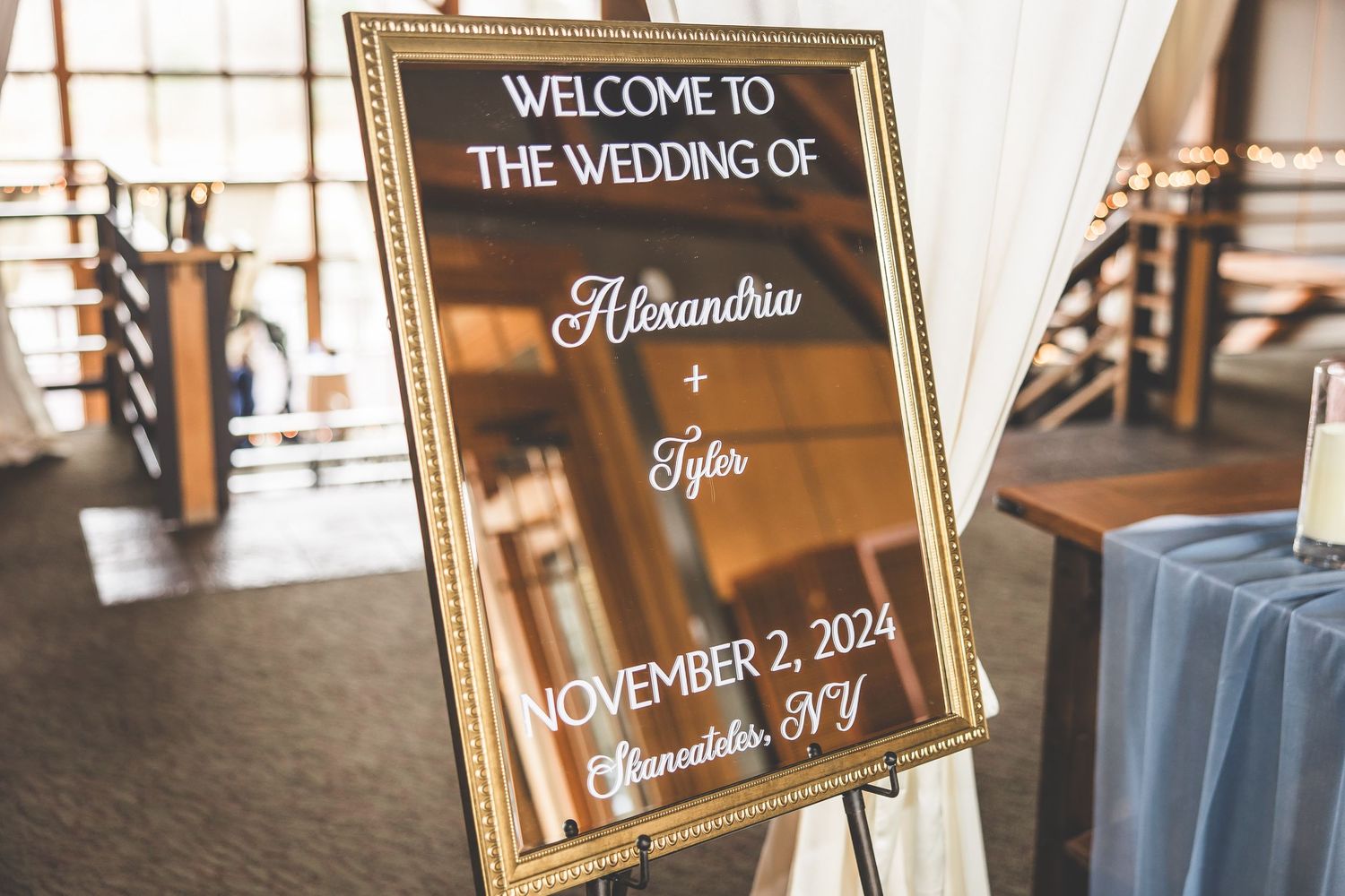Elegant gold-framed wedding welcome sign displaying event date and details.