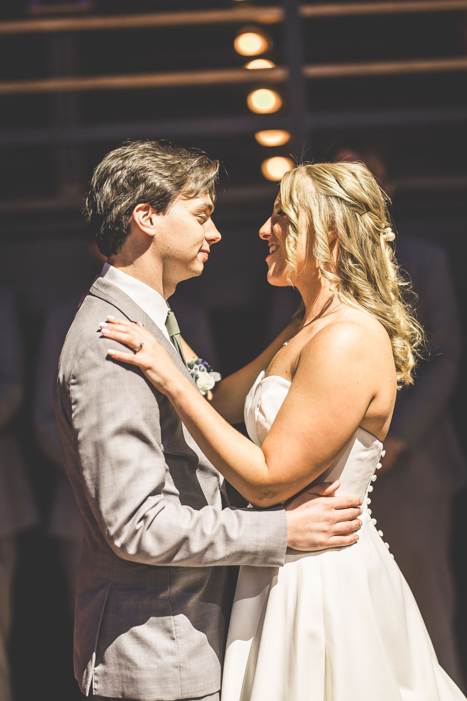 Romantic first dance moment at wedding reception with ambient lighting.