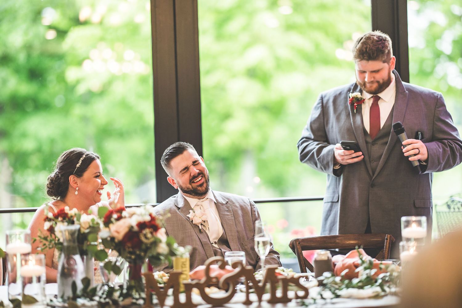 Wedding guests raise their glasses in a celebratory toast during an indoor reception.