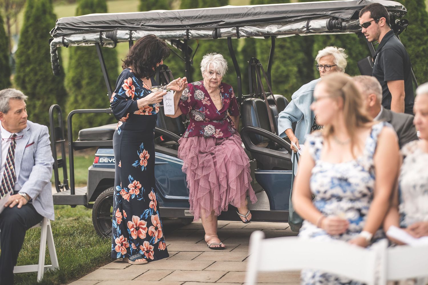Wedding attendees seated in rows at an outdoor garden ceremony venue.