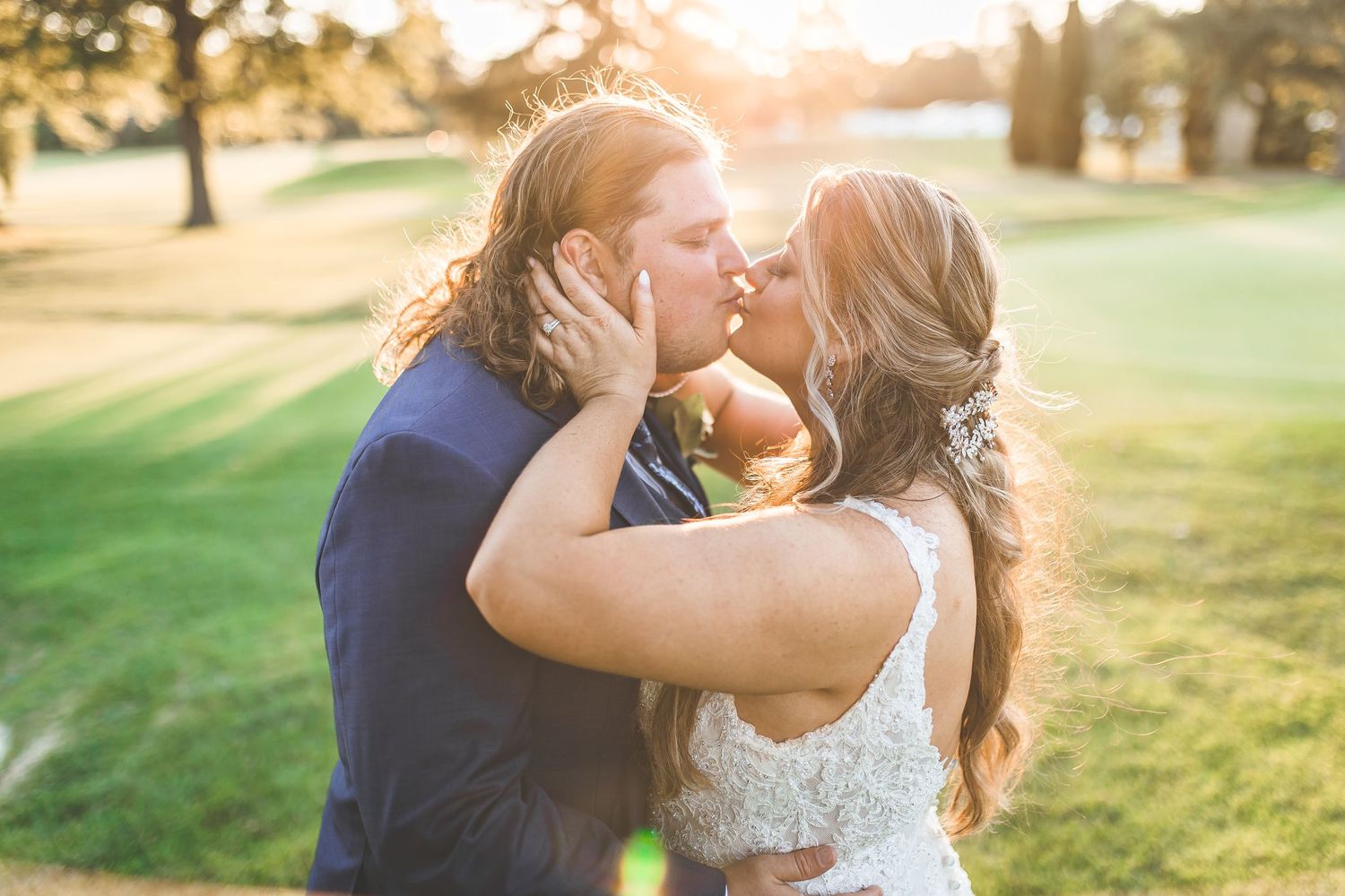 A romantic couple shares tender moments at sunset in a garden setting with golden light.