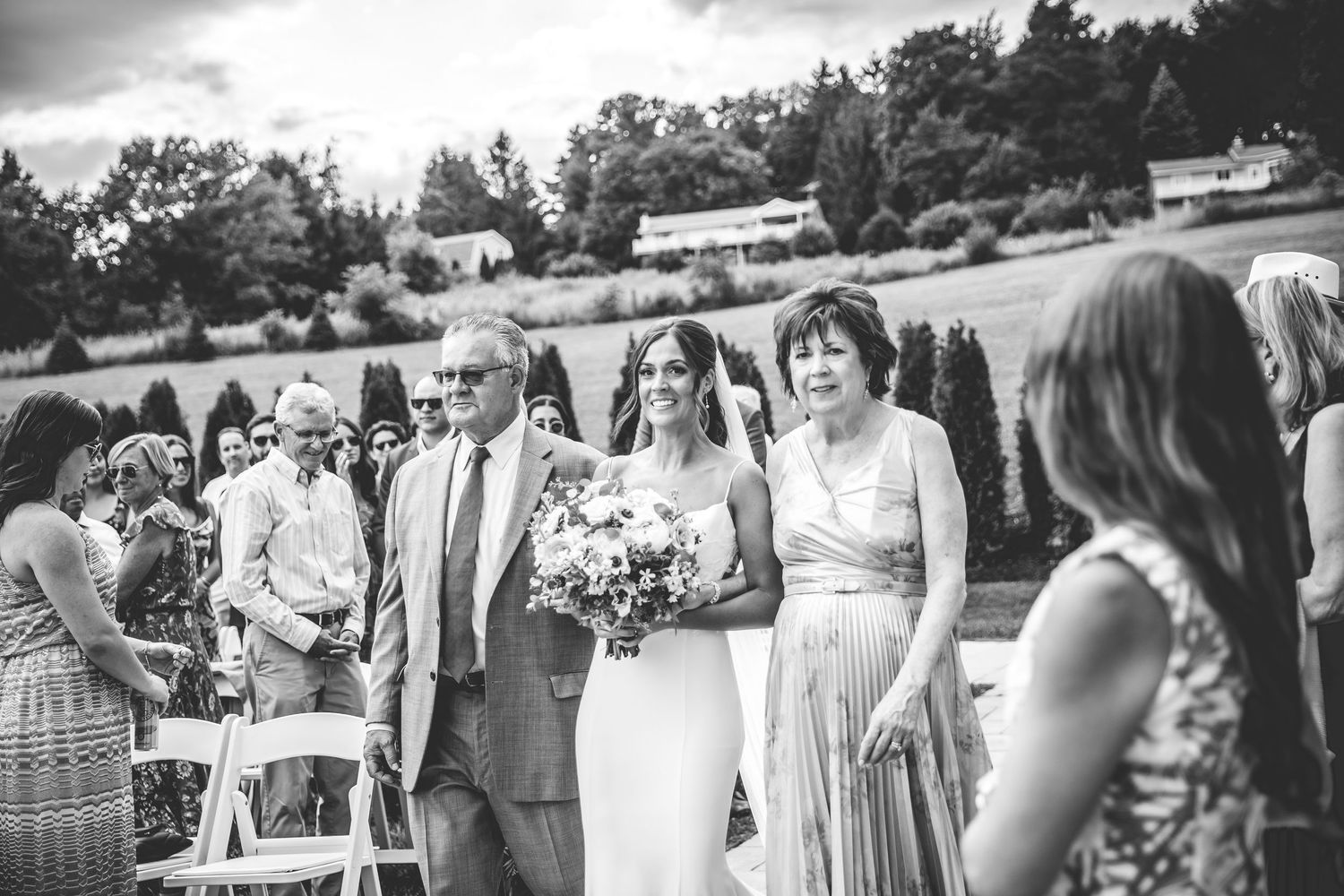 Black and white photo of wedding guests mingling outdoors.