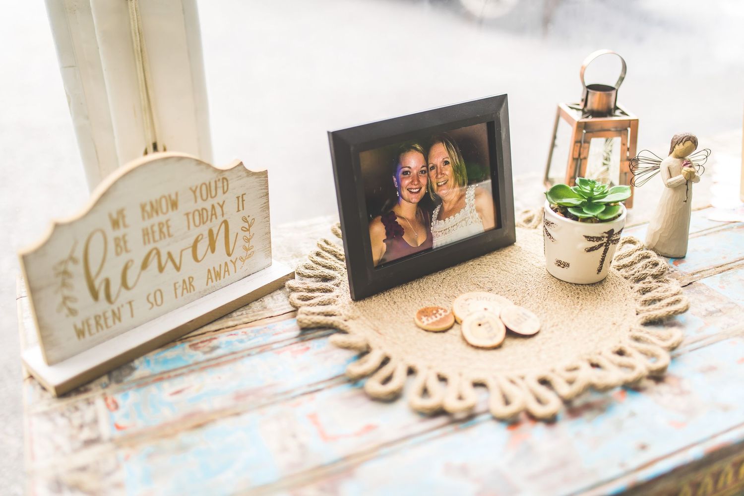 Wedding decor display with vintage frames and Mr & Mrs signage on light blue tablecloth.