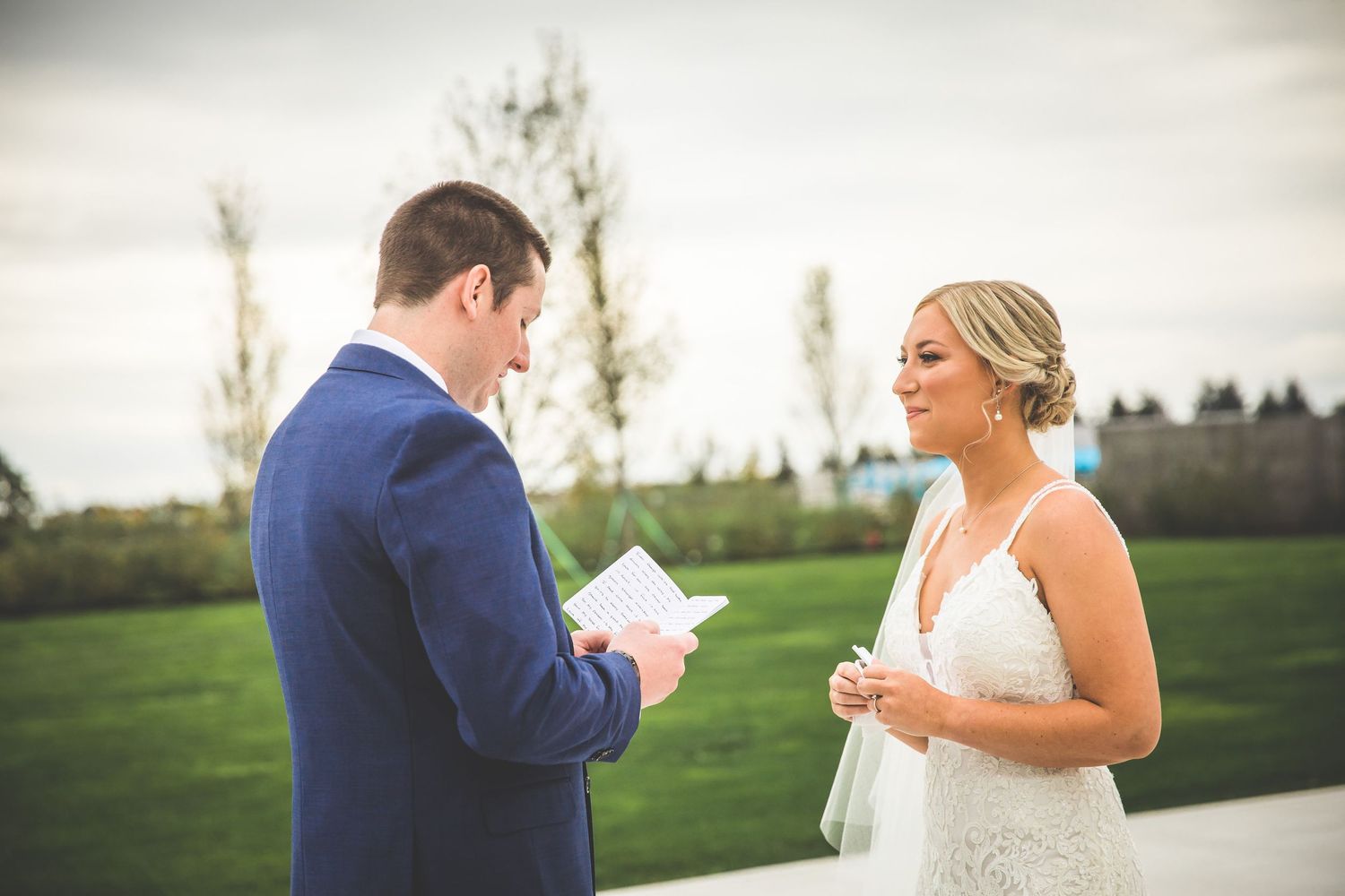 A couple shares a romantic first look moment in an outdoor fall setting.