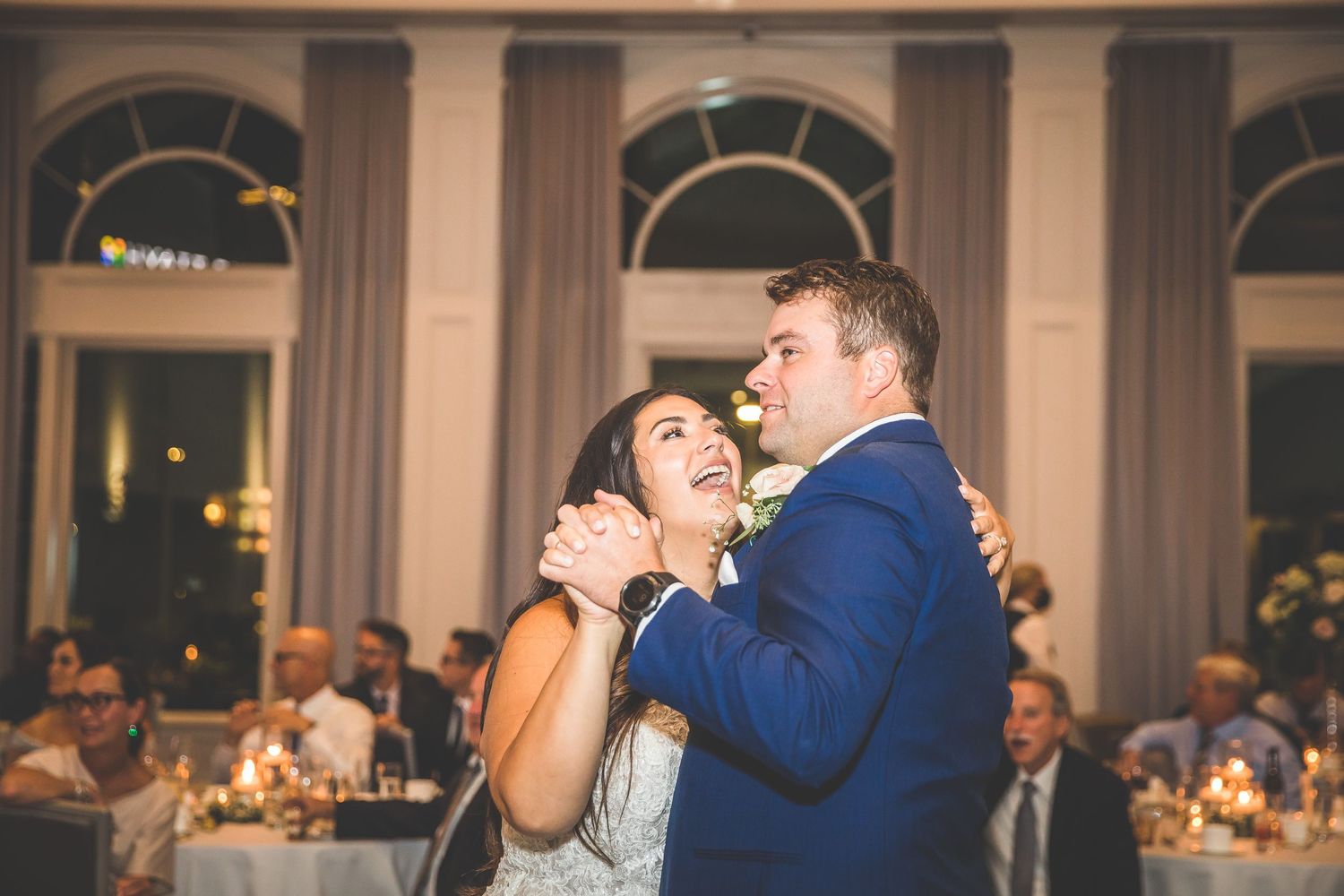Couple sharing an intimate dance moment at an elegant indoor wedding reception.