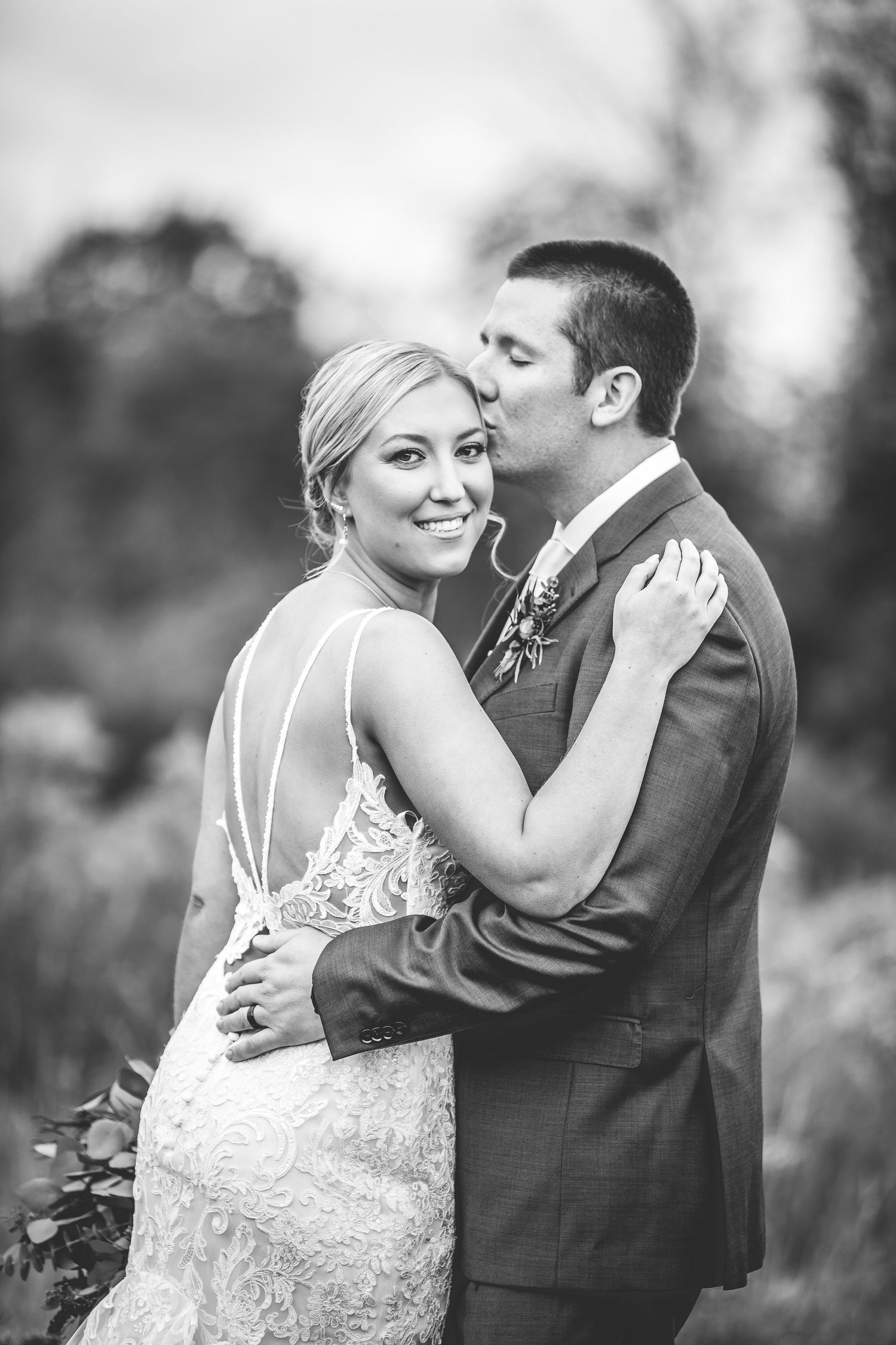 Black and white portrait of couple sharing intimate moment during wedding photos.