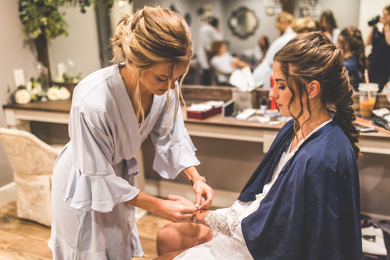 Wedding preparation scene with people in navy and white attire.