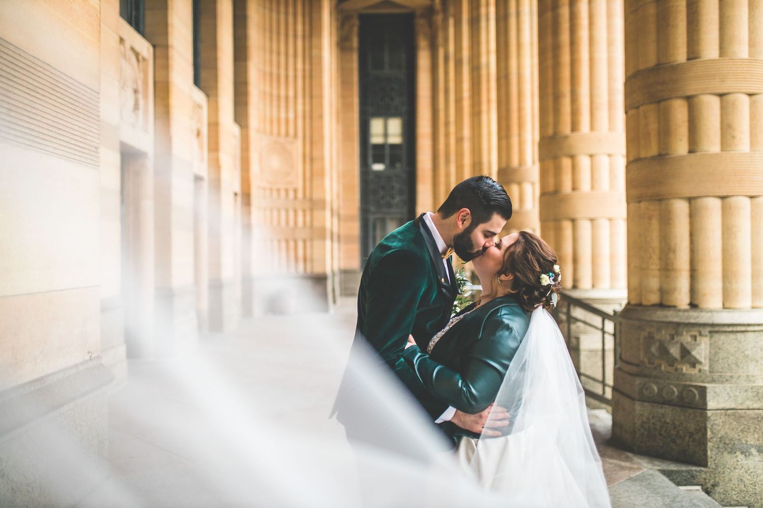 Series of romantic wedding portraits captured under classical stone colonnade.