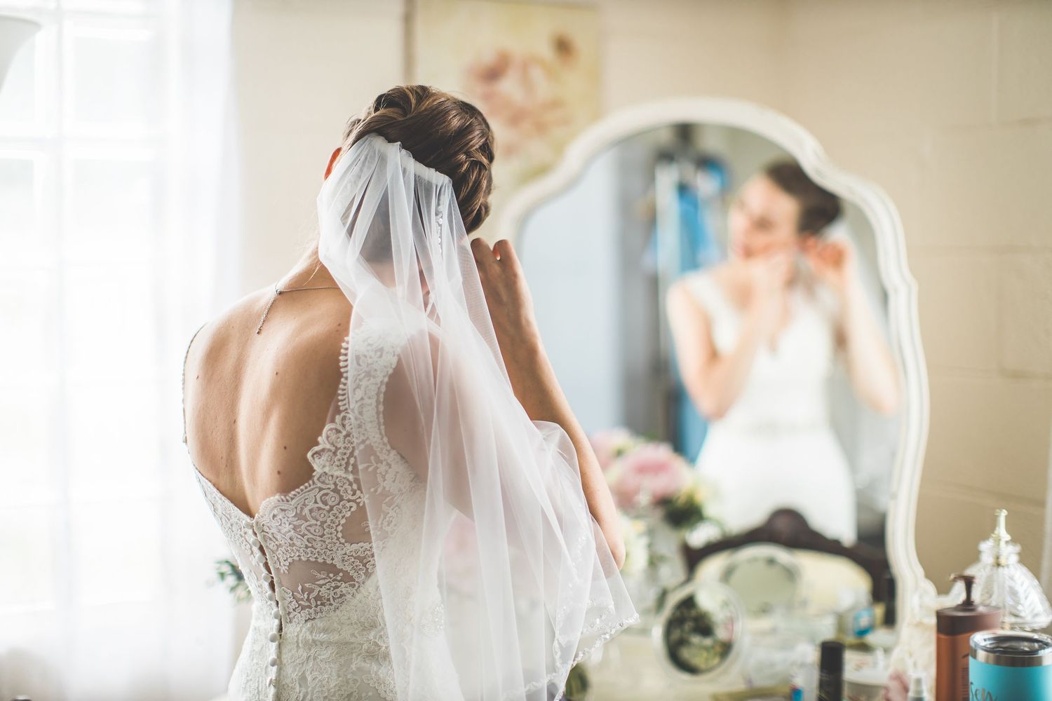Elegant wedding dress details showing delicate lace and beading in a bridal preparation room.