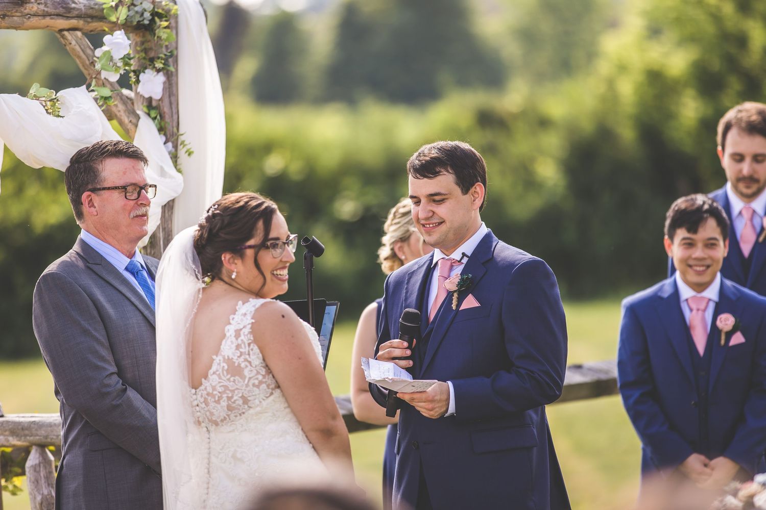 Wedding ceremony participants exchanging vows under bright natural lighting.