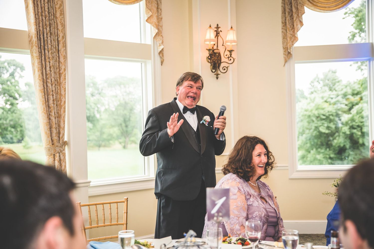 Candid reception moments captured as guests celebrate during wedding dinner.
